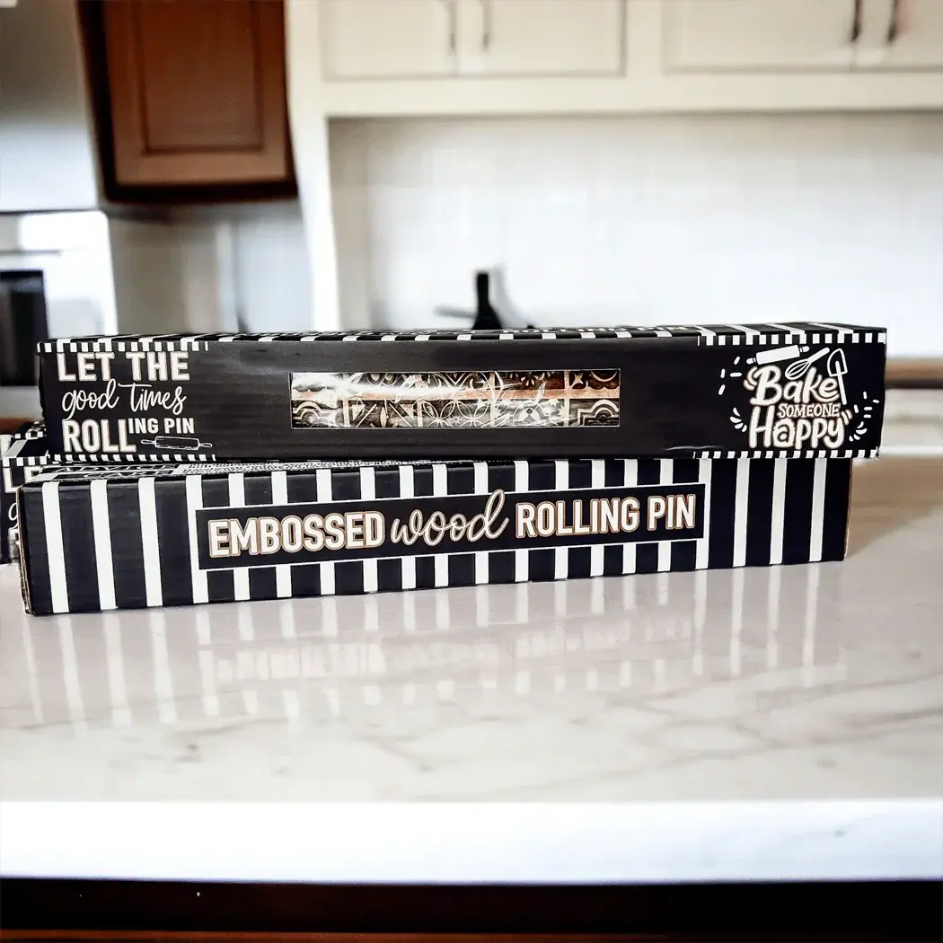 Boxed rolling pin with decorative text on a kitchen counter