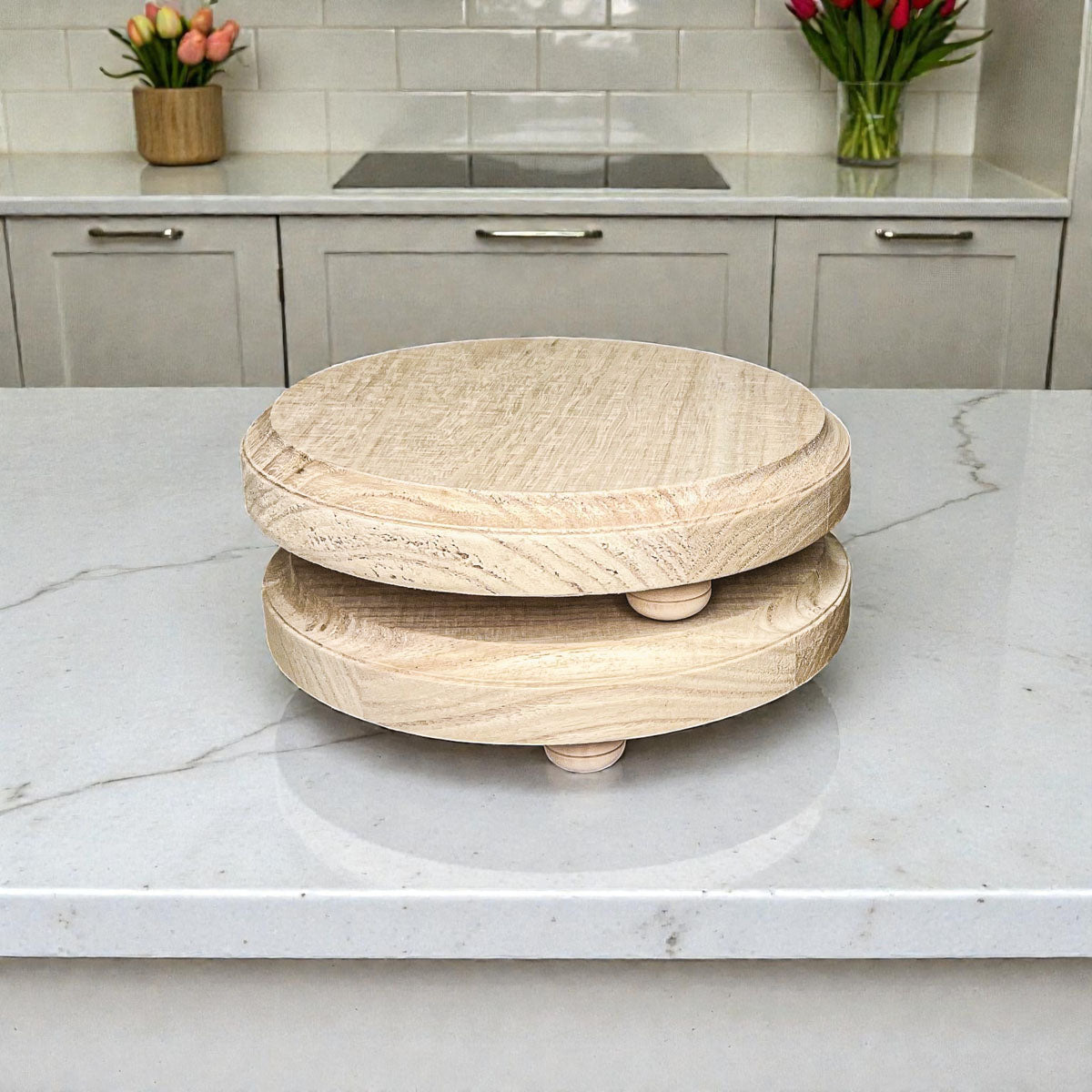 Wooden turntable on a kitchen counter with flowers in the background