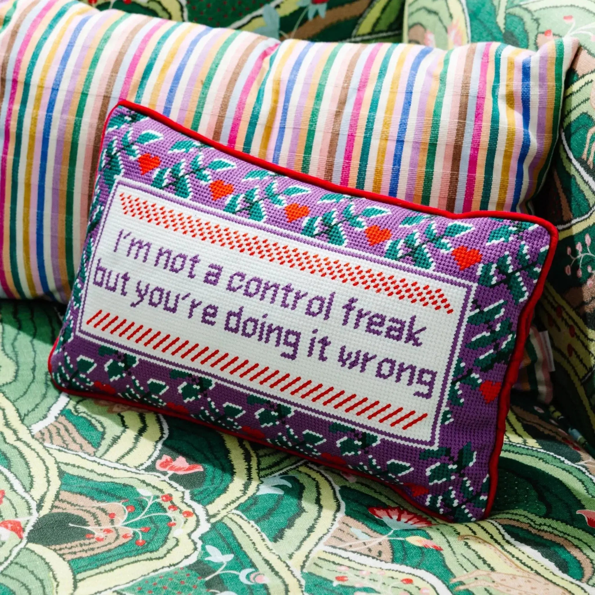 Funny embroidered pillow with quote 'I'm not a control freak but you're doing it wrong' on floral couch, cozy home decor