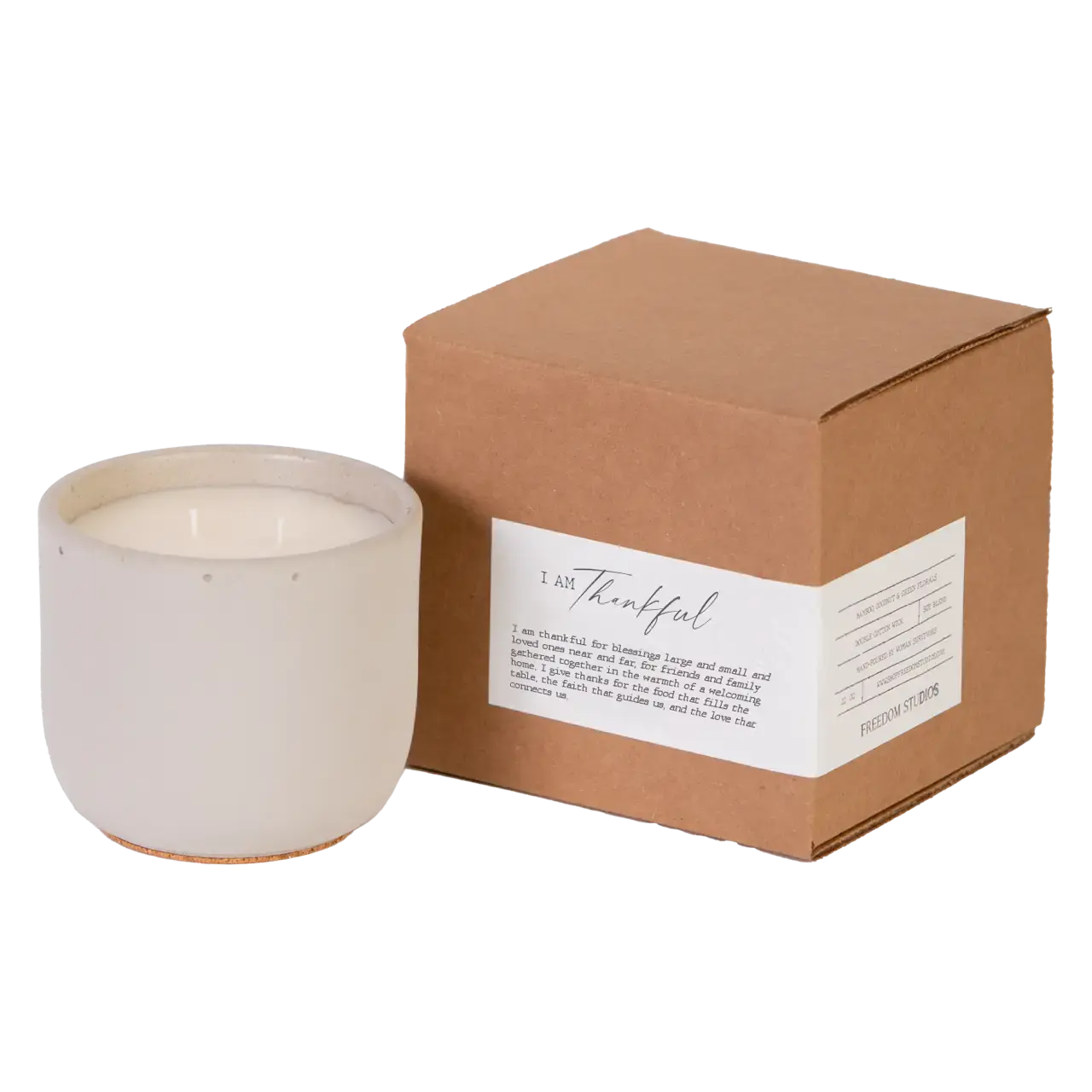 White candle in a ceramic holder next to a brown cardboard box with a label on a white background