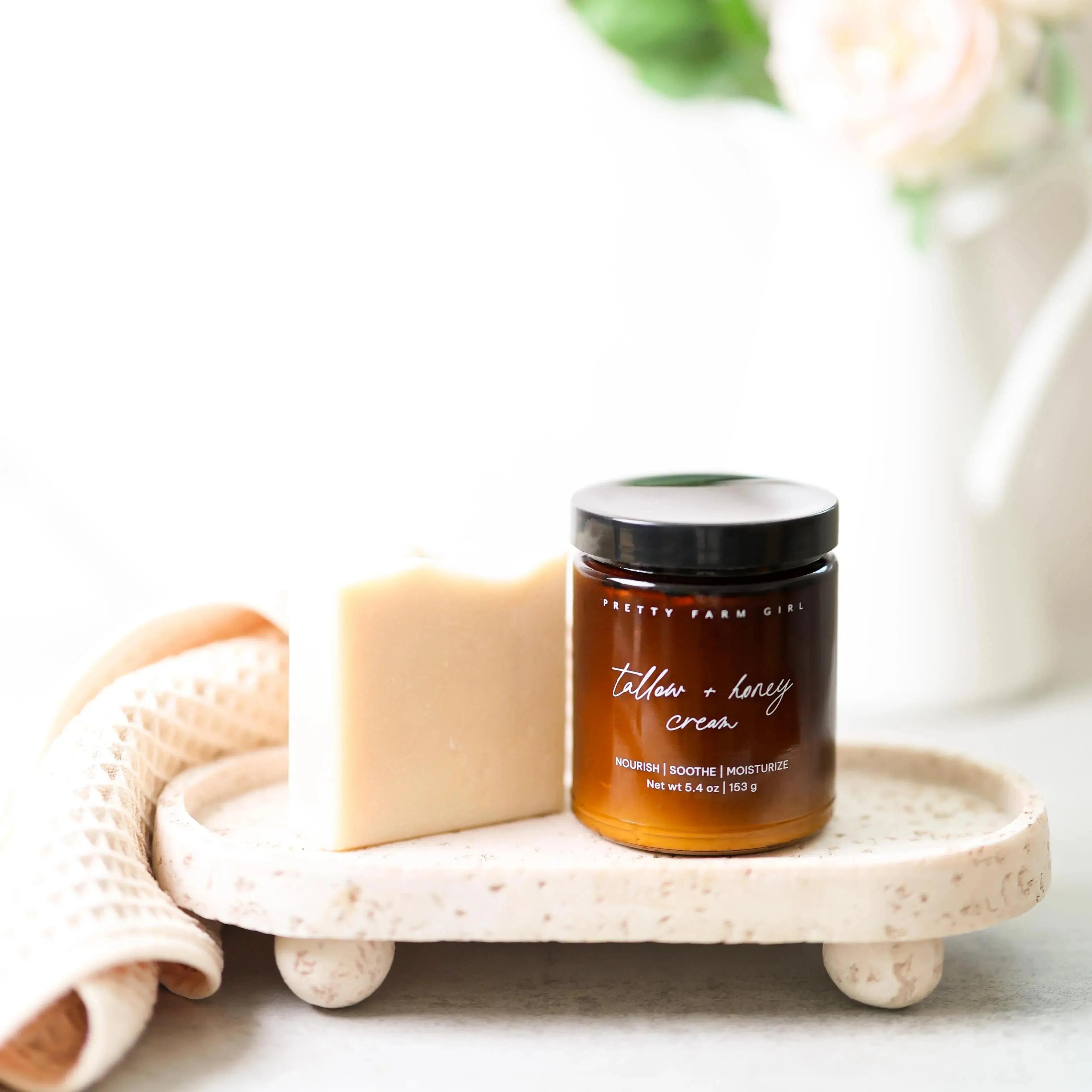 Tallow + honey cream jar and bar soap on rustic tray, cozy farmhouse bath essentials