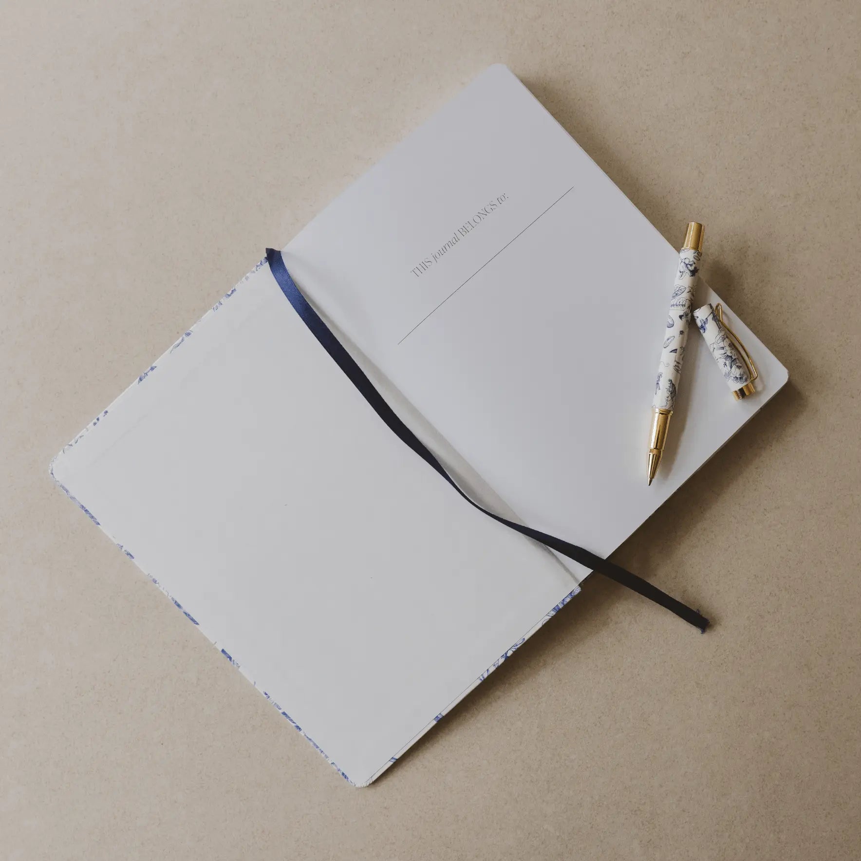 Open notebook with a pen on a beige background