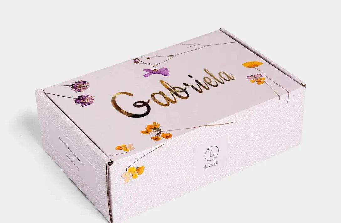 Personalized gift box with floral design, gold name 'Gabriela', and 'Lizush' logo, ideal for cozy home decor gifts.