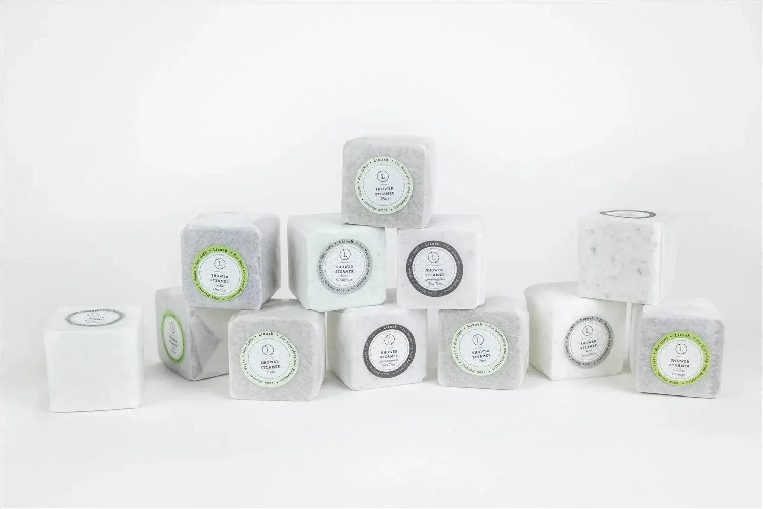 Assorted shower steamers in white and gray cubes with scents like eucalyptus, pine, and orange for bath essentials