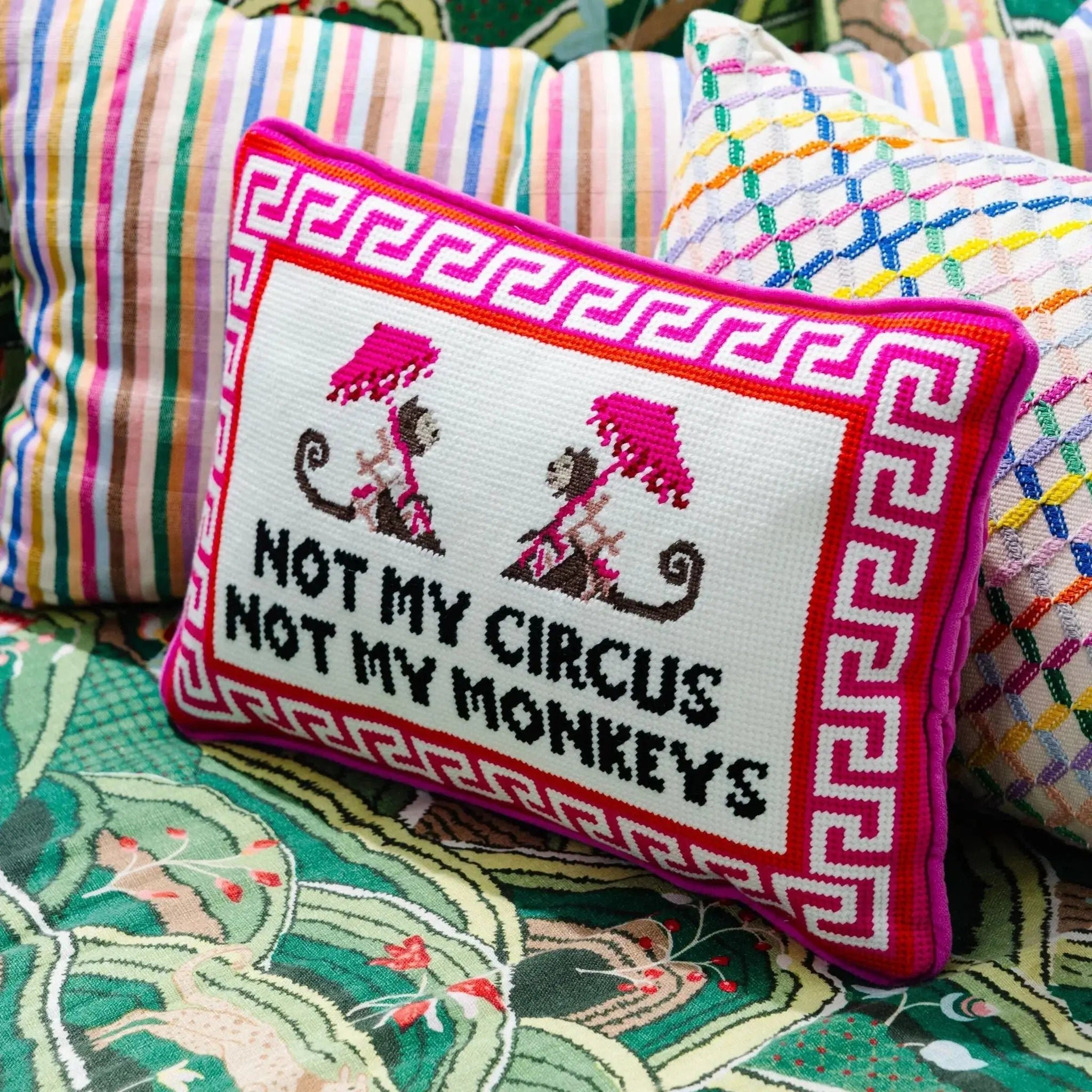 Needlepoint pillow with monkeys and "Not My Circus Not My Monkeys" pink Greek key border on a colorful pattern