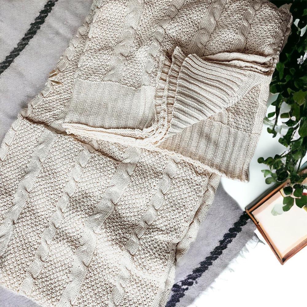 Cozy cream cable knit blanket with farmhouse charm, perfect for warm, peaceful living spaces