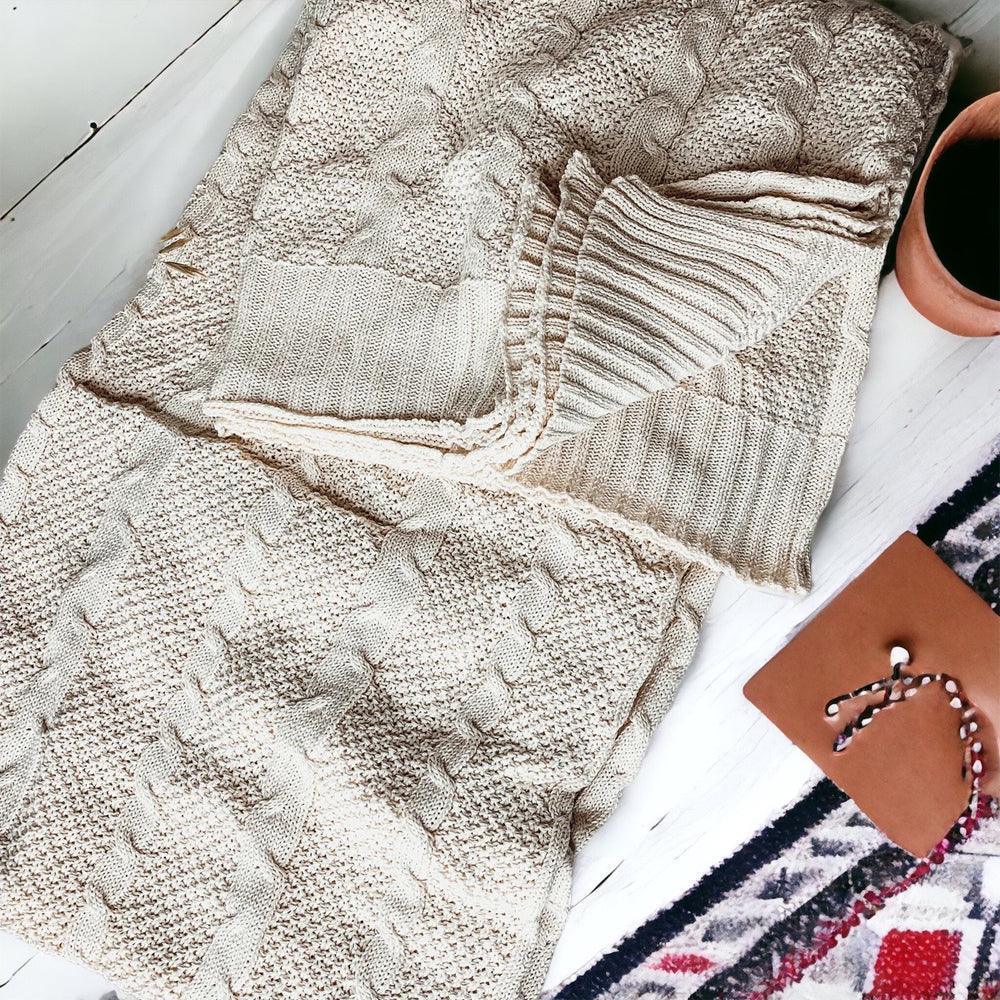 Cozy cream cable knit blanket with farmhouse decor, perfect for warm, peaceful living spaces