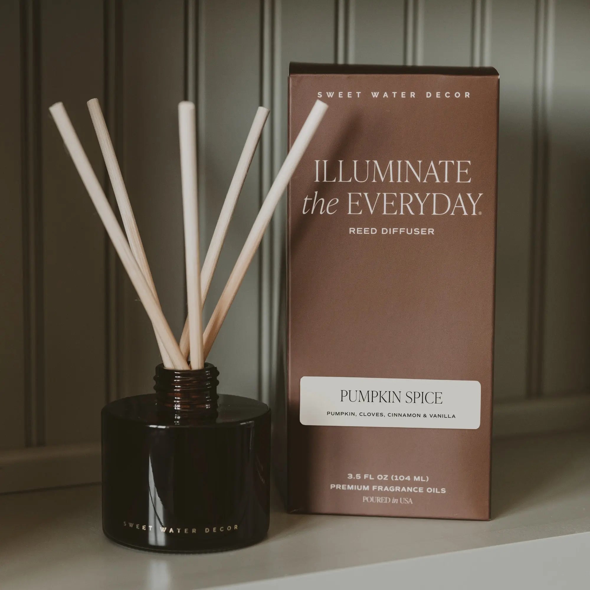 Reed diffuser with packaging labeled 'Pumpkin Spice' by Sweet Water Decor on a neutral background.