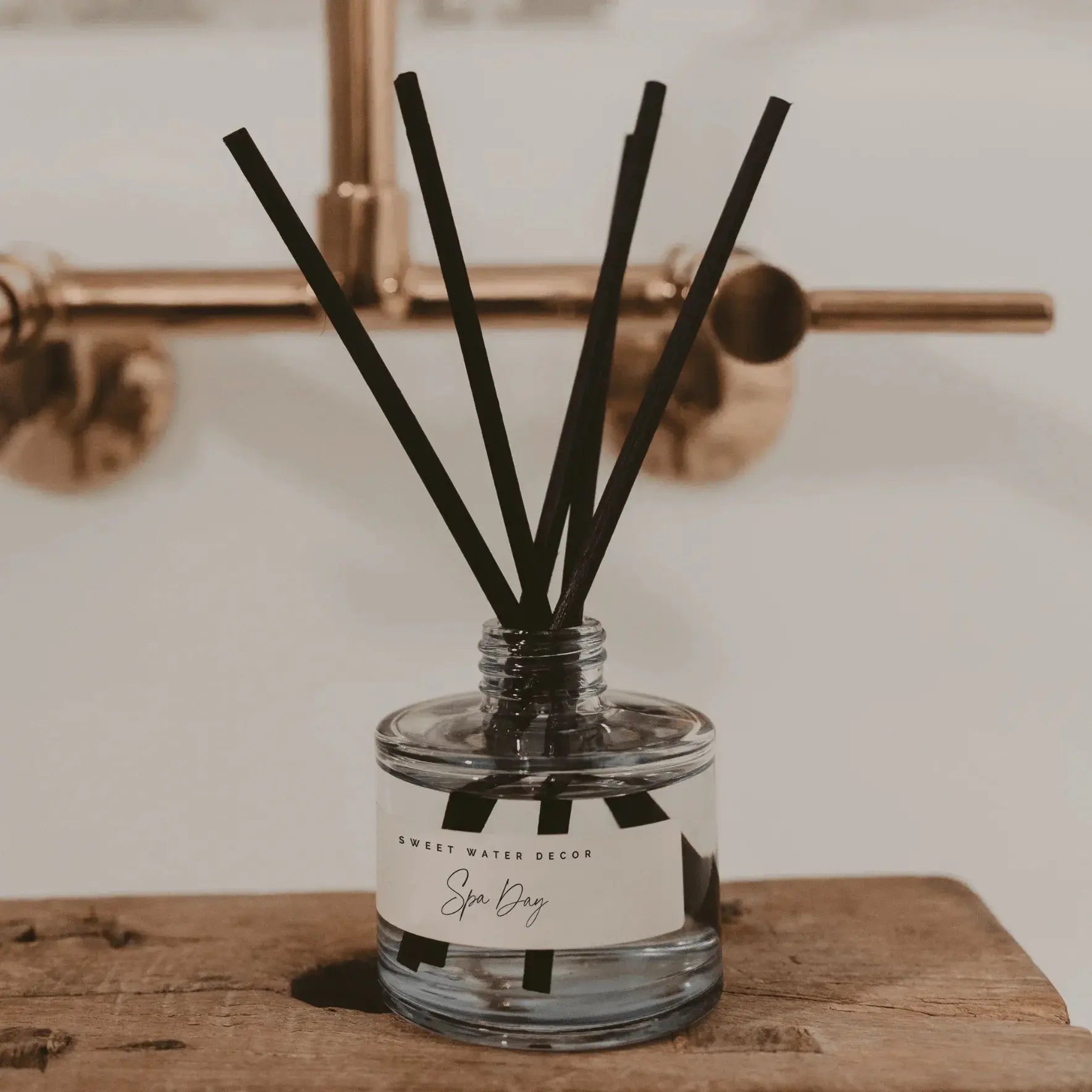 Spa Day reed diffuser on rustic wood, farmhouse bathroom decor with gold fixtures
