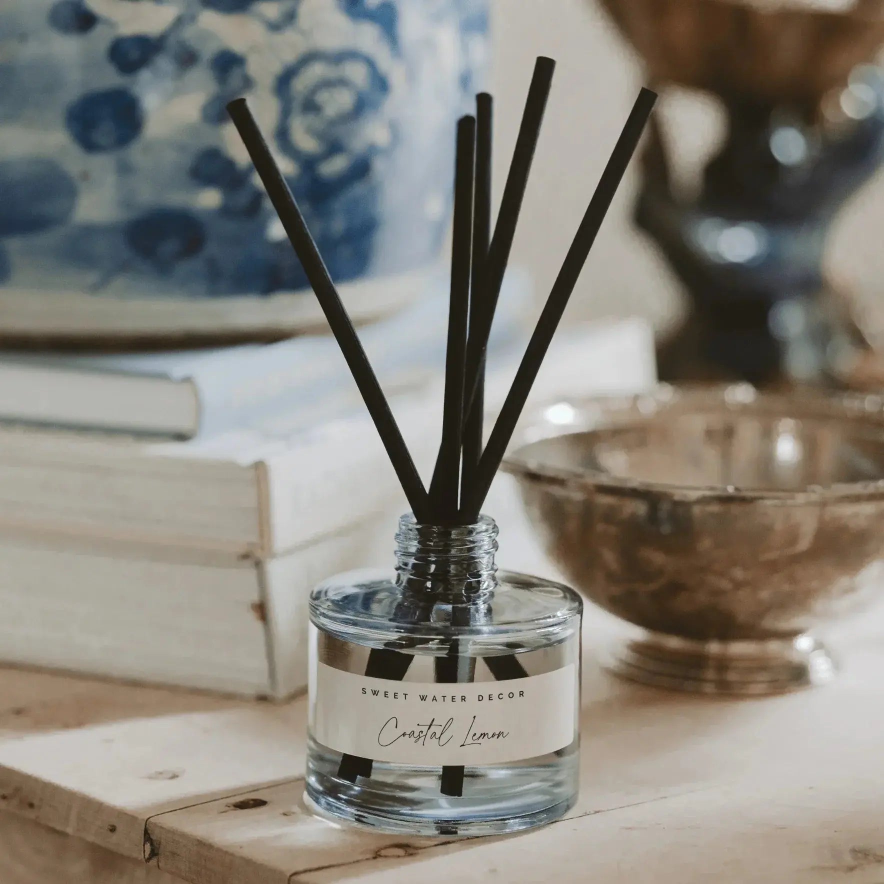 Coastal Lemon reed diffuser in clear glass bottle with black reeds, farmhouse home decor on wooden surface