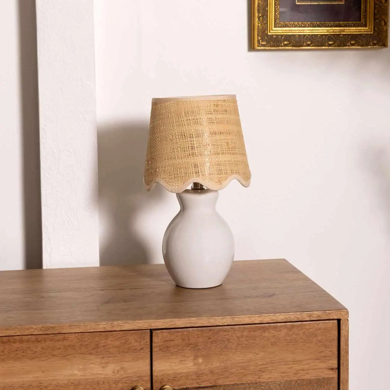 White ceramic table lamp with woven raffia shade on wooden dresser, farmhouse cottage decor