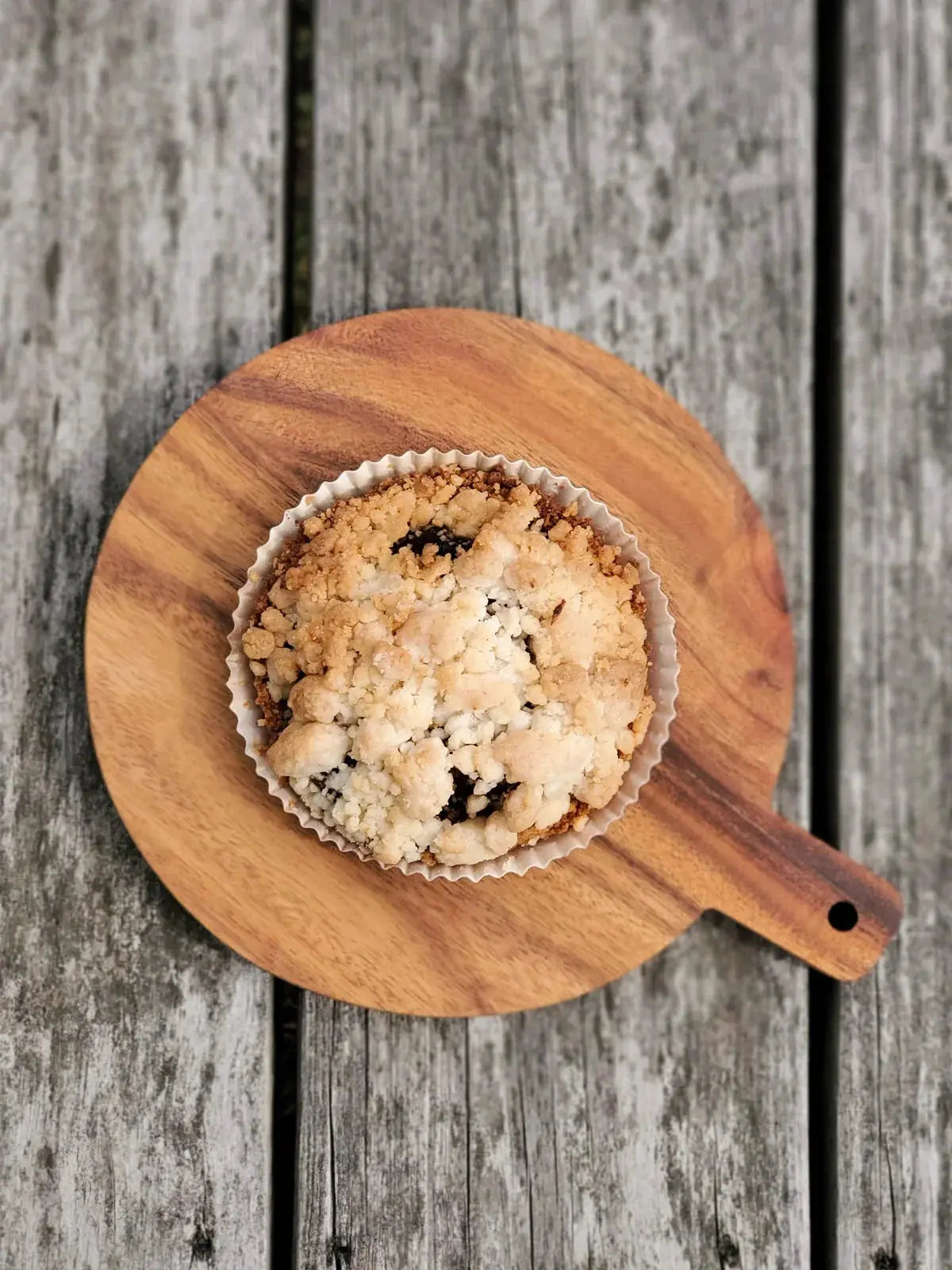 Cozy farmhouse-style crumble muffin on wooden board, rustic home decor vibe