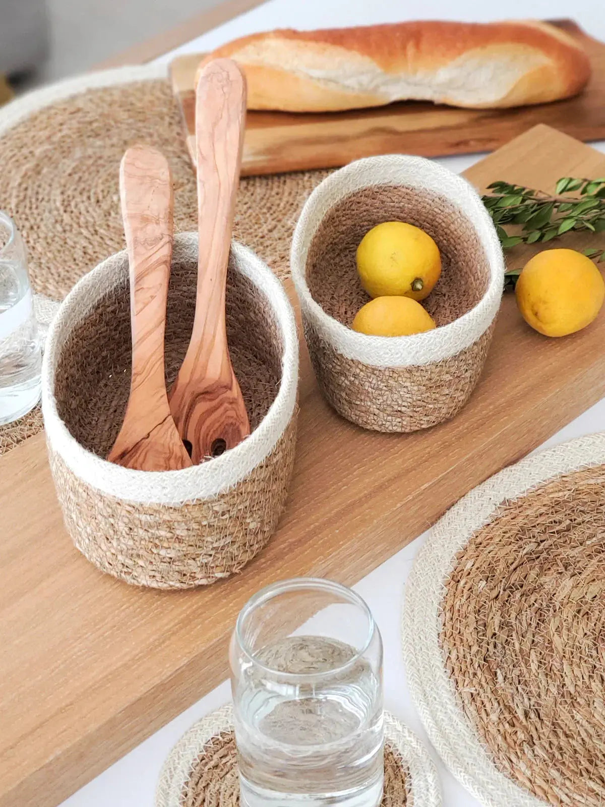 Woven seagrass baskets with wooden spoons and lemons, farmhouse kitchen decor on wood tray