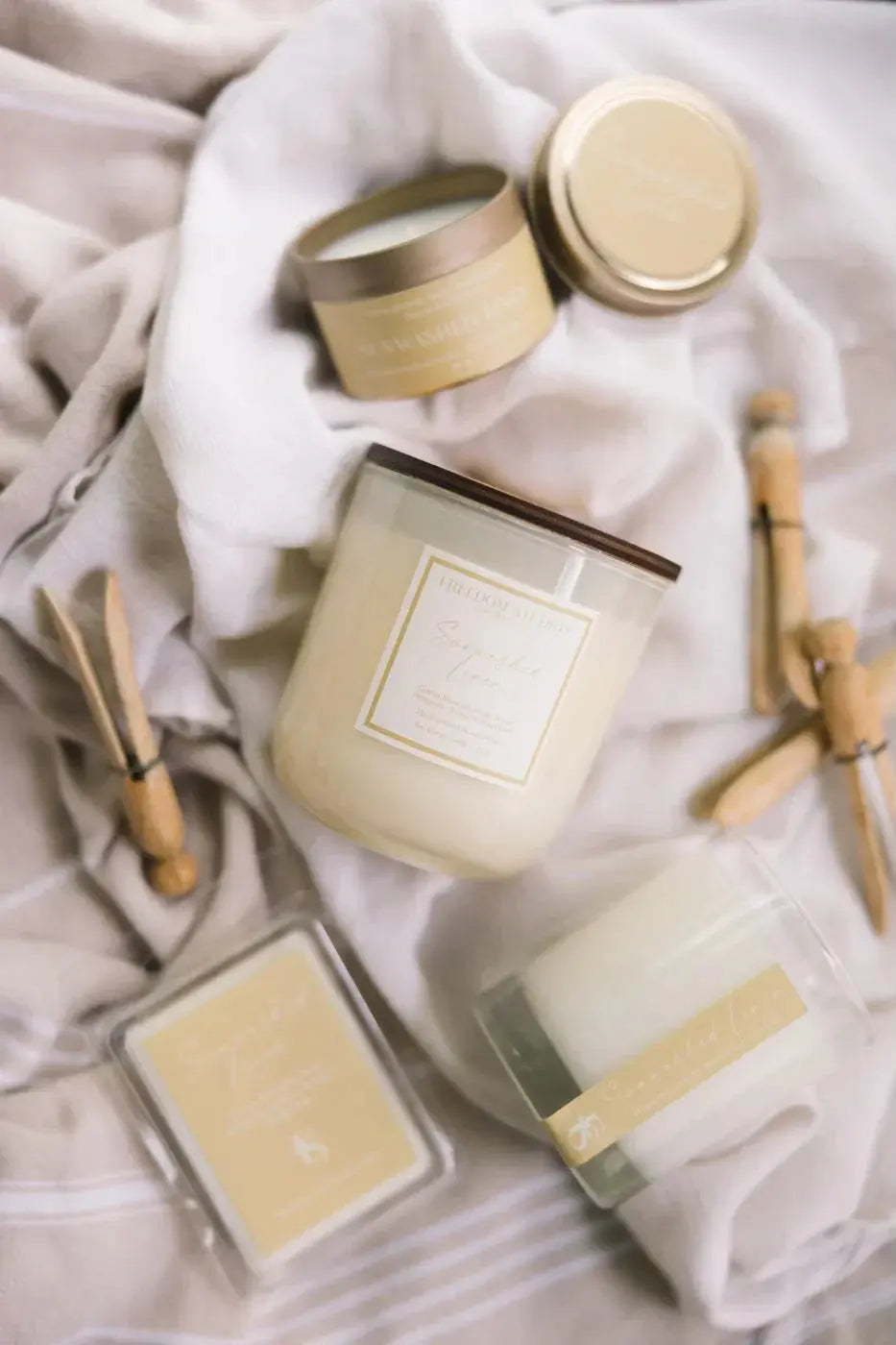 Sunwashed Linen scented candles and wax melts in cozy farmhouse style packaging on soft linens