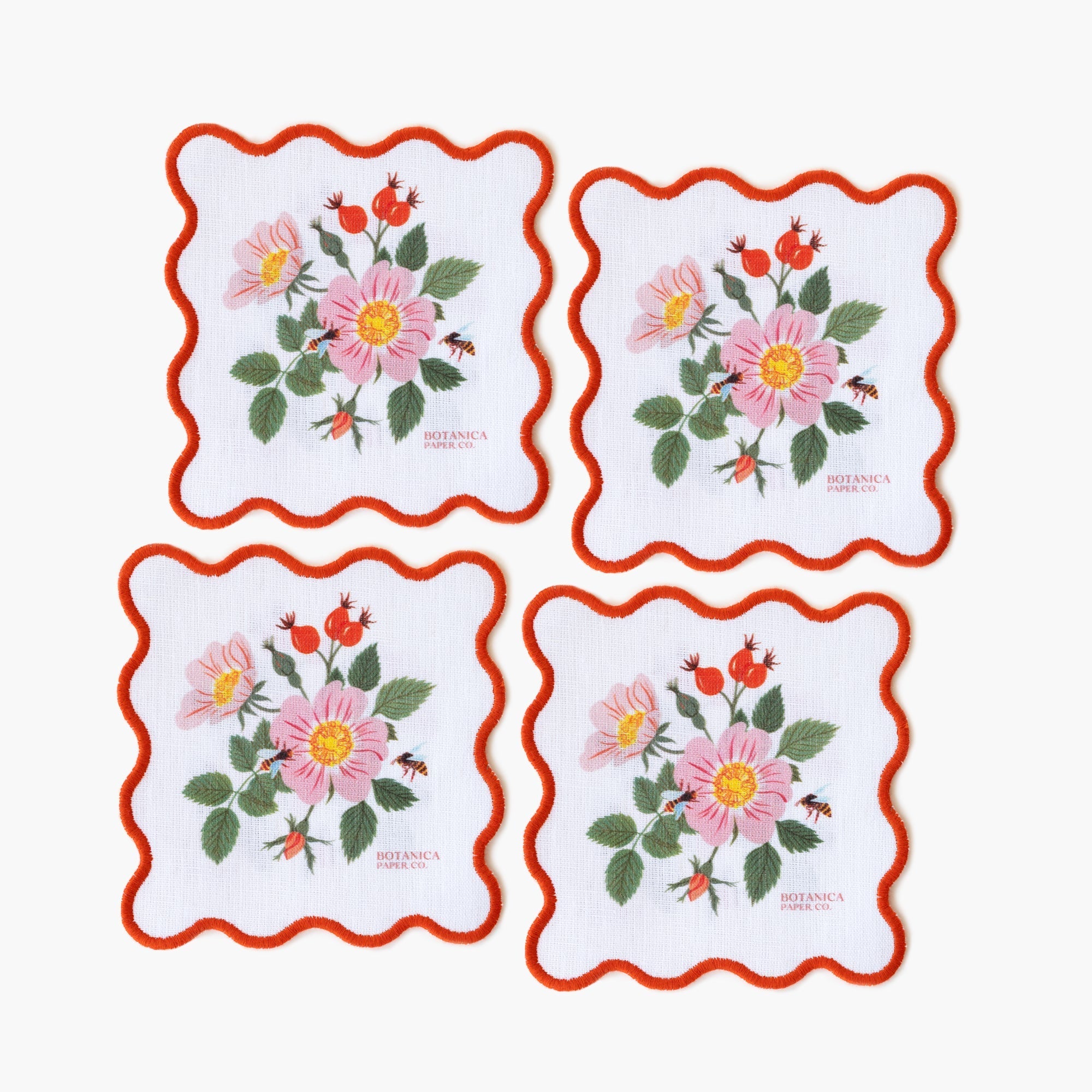 Set of four floral coasters with red borders on a white background