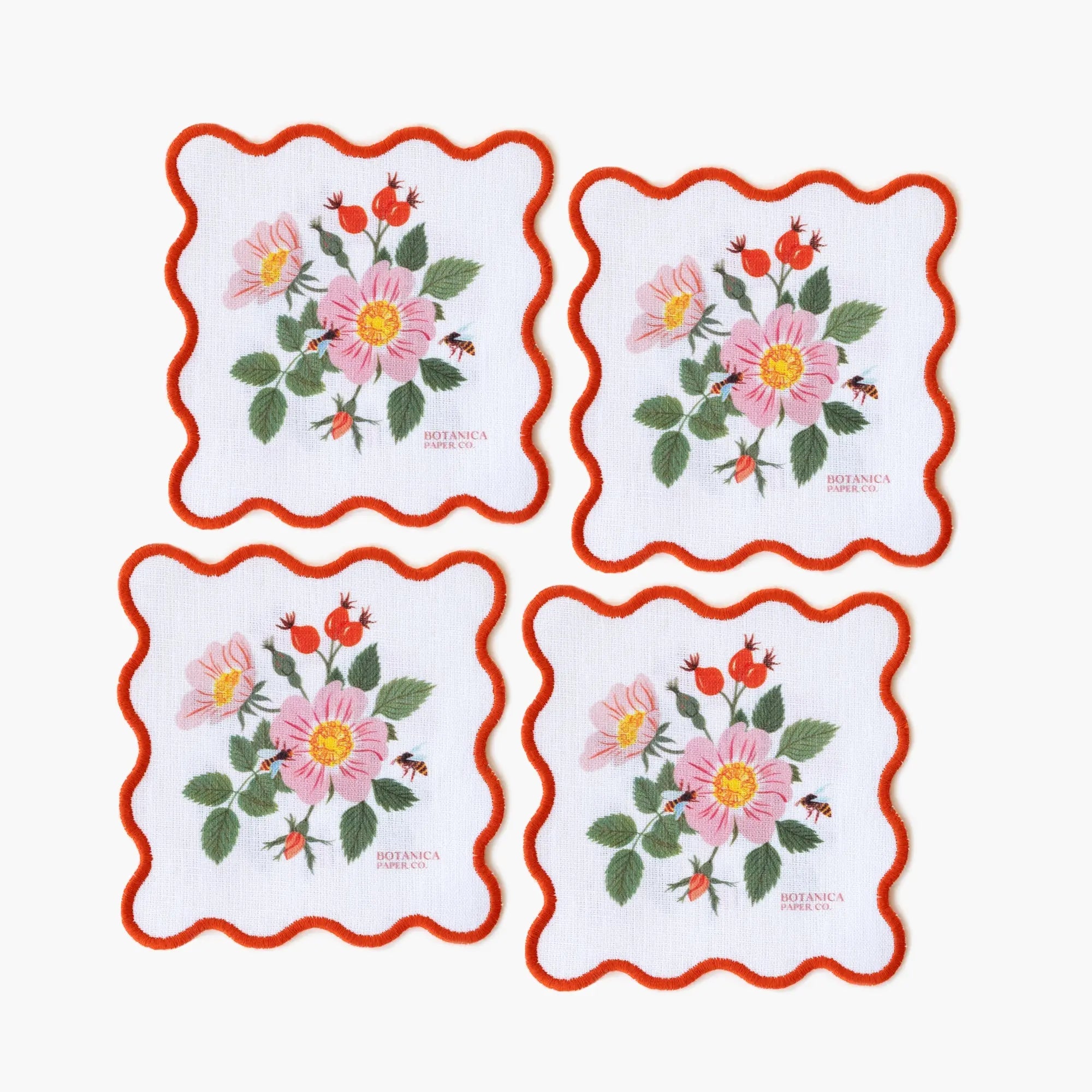 Set of four floral coasters with red borders on a white background