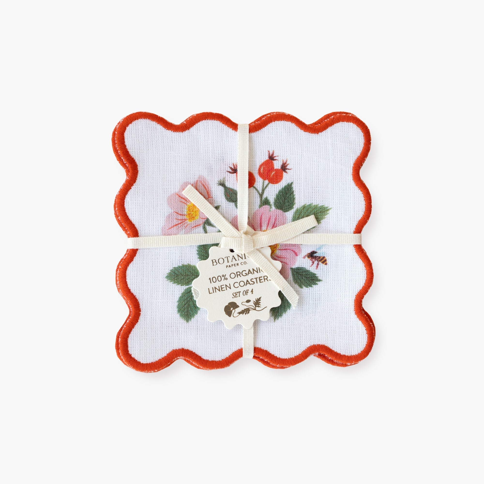 Set of floral coasters with a red border in a decorative box on a white background