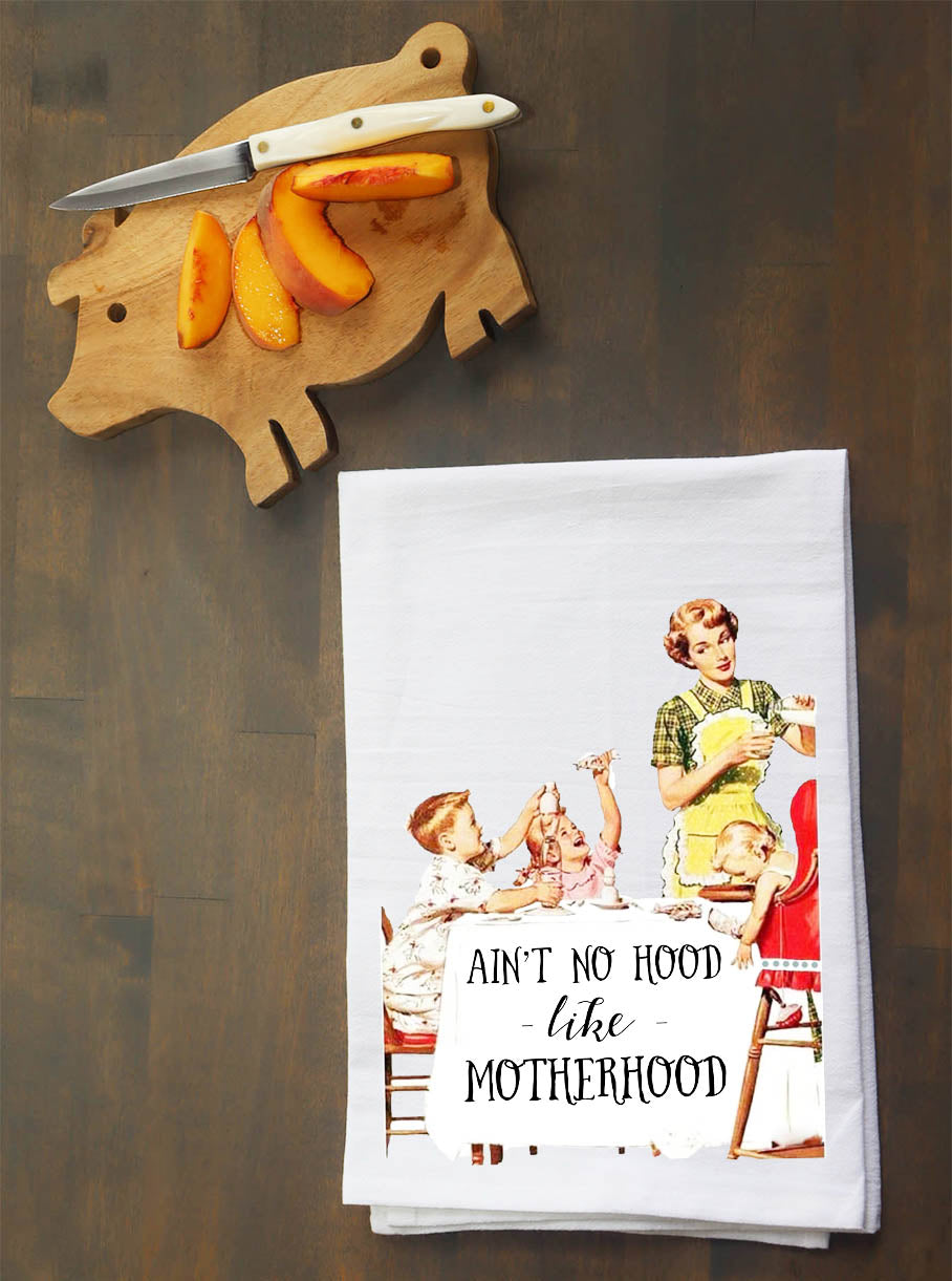Tea towel with vintage illustration of a mother and children, placed on a wooden surface with a cutting board and knife.