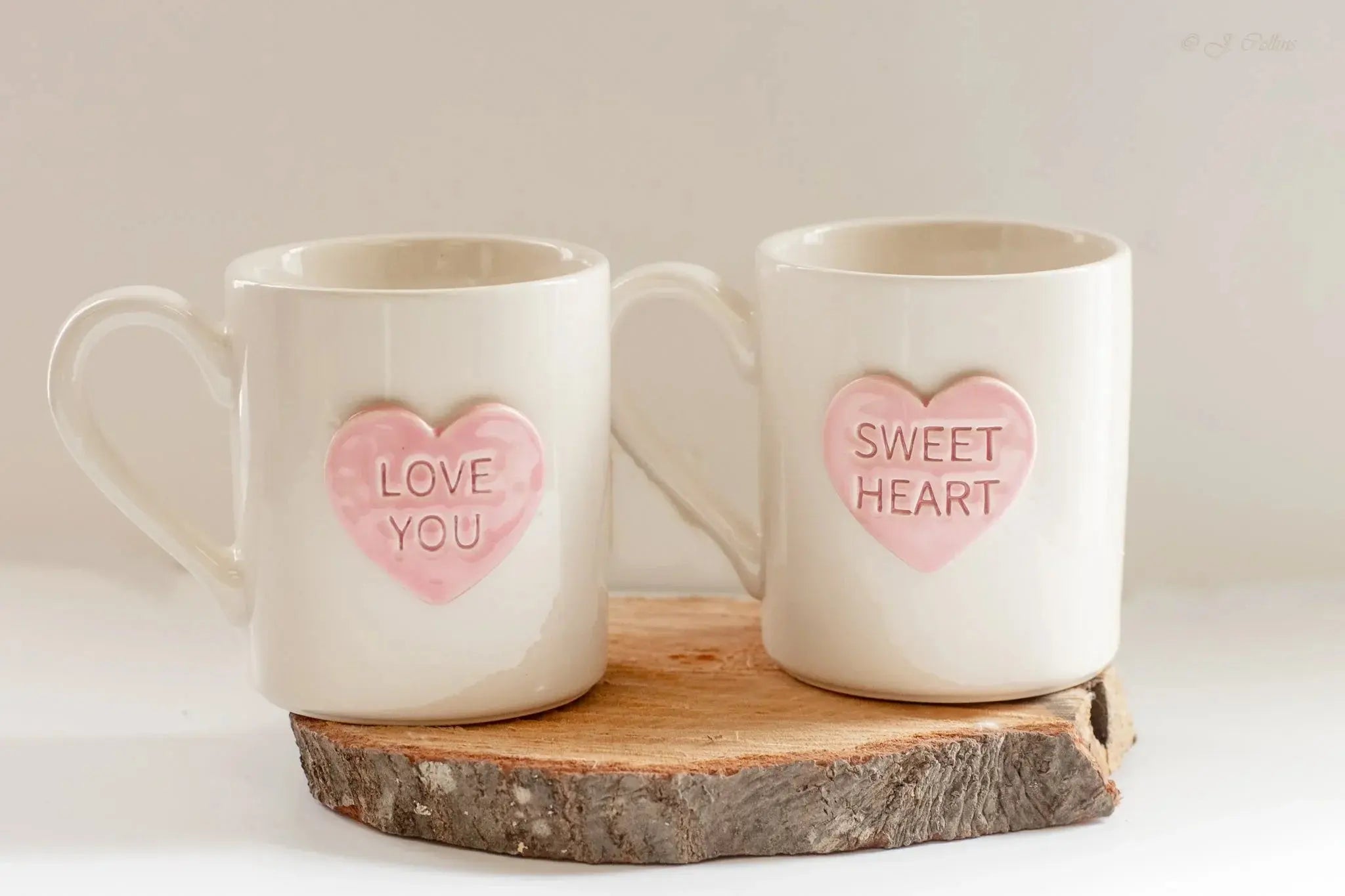 Cozy farmhouse ceramic mugs with pink heart designs saying 'Love You' and 'Sweet Heart', perfect for Valentine's gifts.