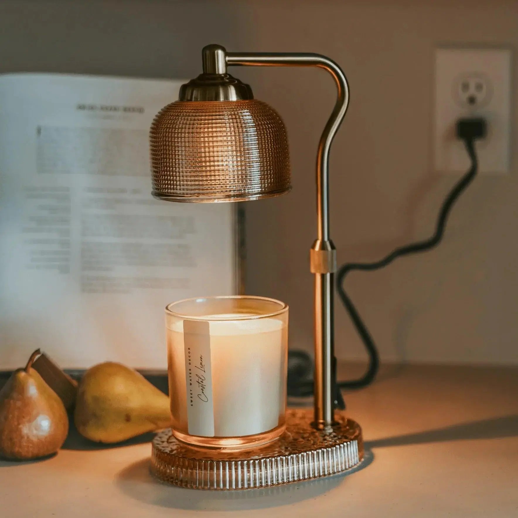 Cozy farmhouse candle warmer with textured glass shade, glowing over a scented candle, perfect for cottage decor