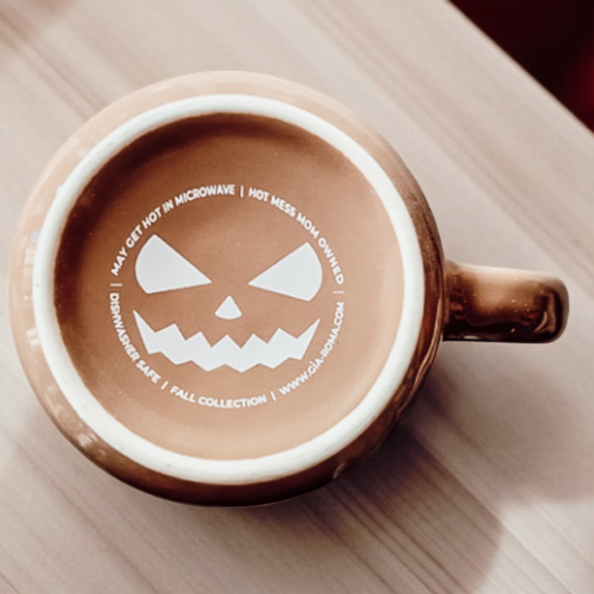 Ceramic mug with a Halloween-themed design on a wooden surface