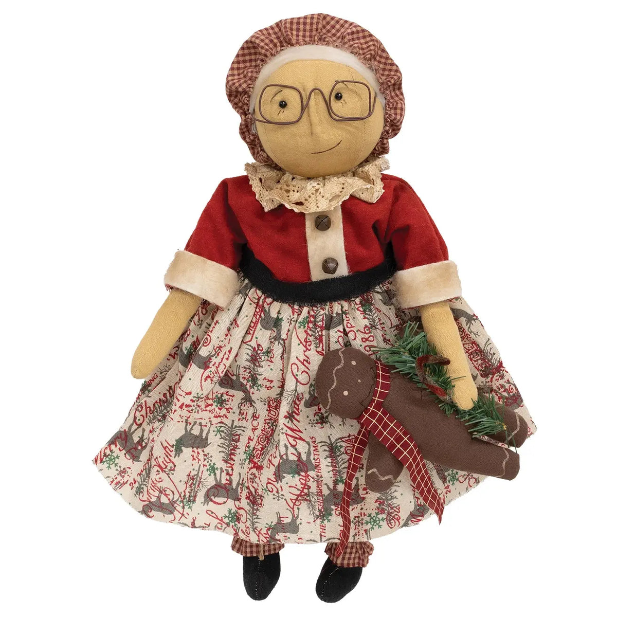 A rustic Christmas rag doll with a red top, patterned skirt, and red-and-beige checkered bonnet, holding a brown gingerbread cookie and green pine sprigs against a white background.