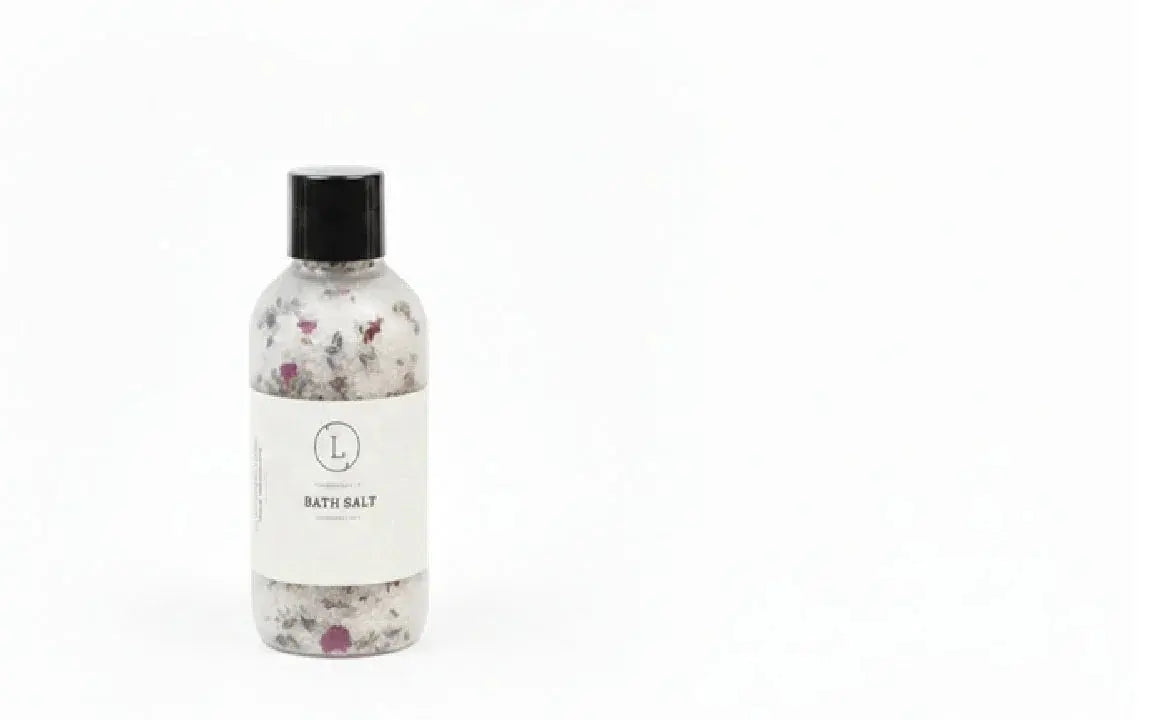 Clear bottle of bath salts with dried flowers, black cap, labeled 'Bath Salt' for cozy home spa relaxation