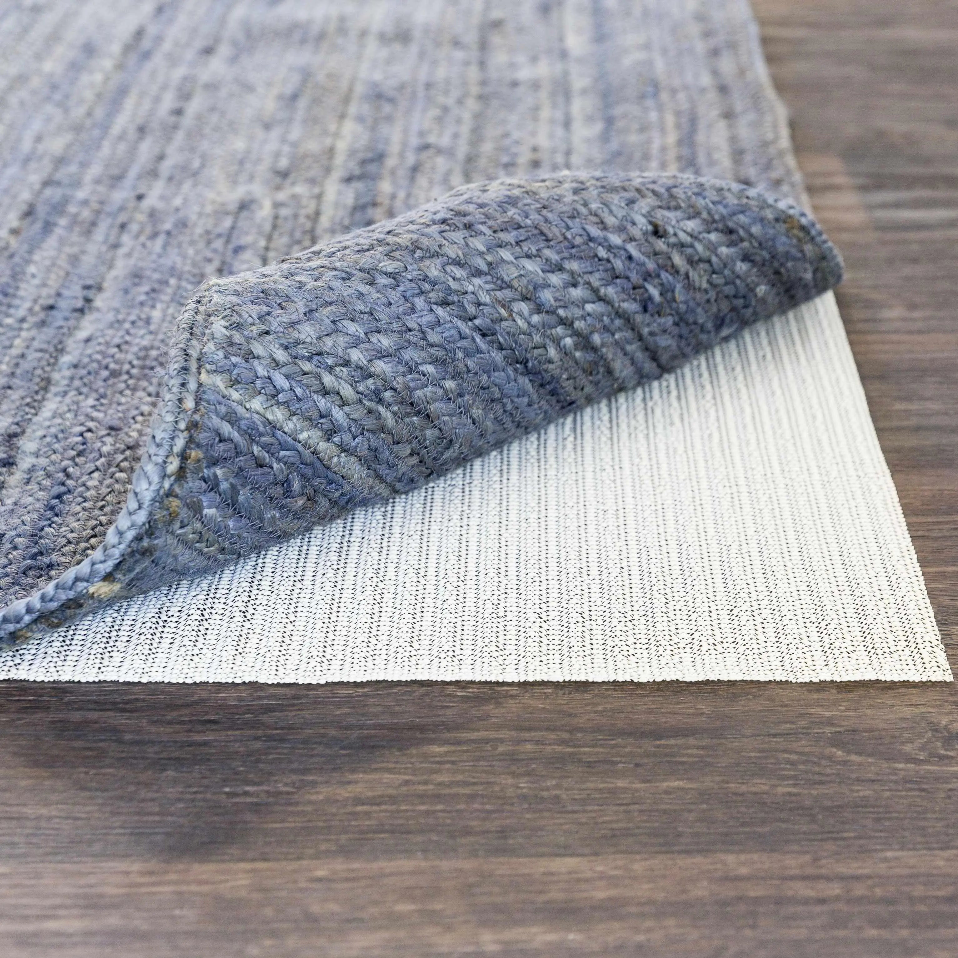 Gray woven rug with textured pattern on wooden floor, cozy farmhouse decor