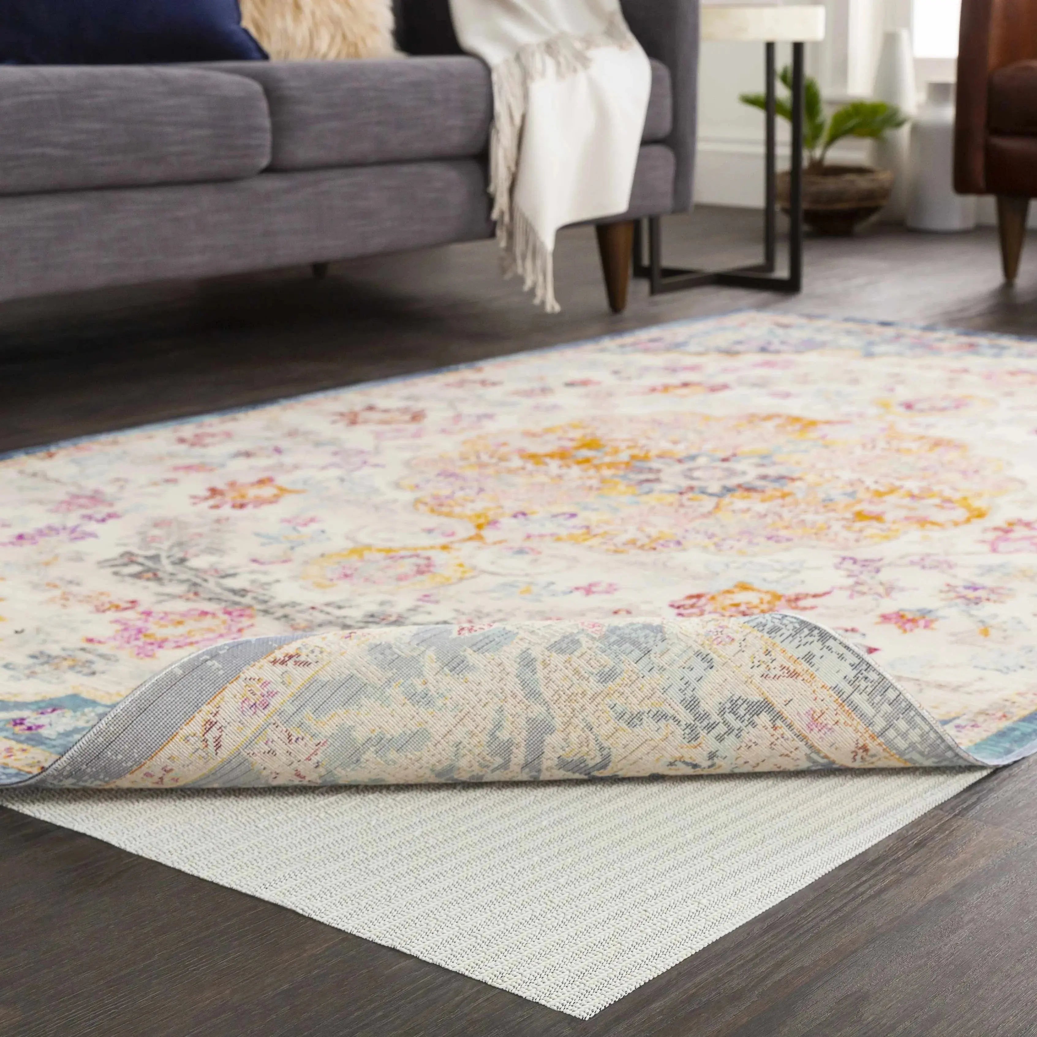 Floral patterned area rug with pastel colors, shown on hardwood floor in cozy living room setting