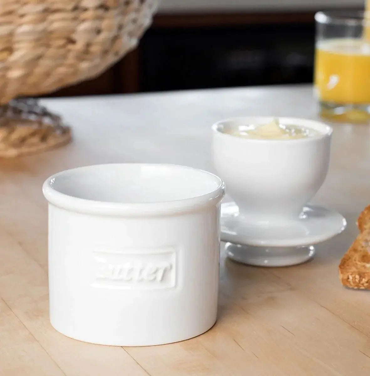 White ceramic butter crock with embossed label, farmhouse kitchen decor, cozy breakfast table setting