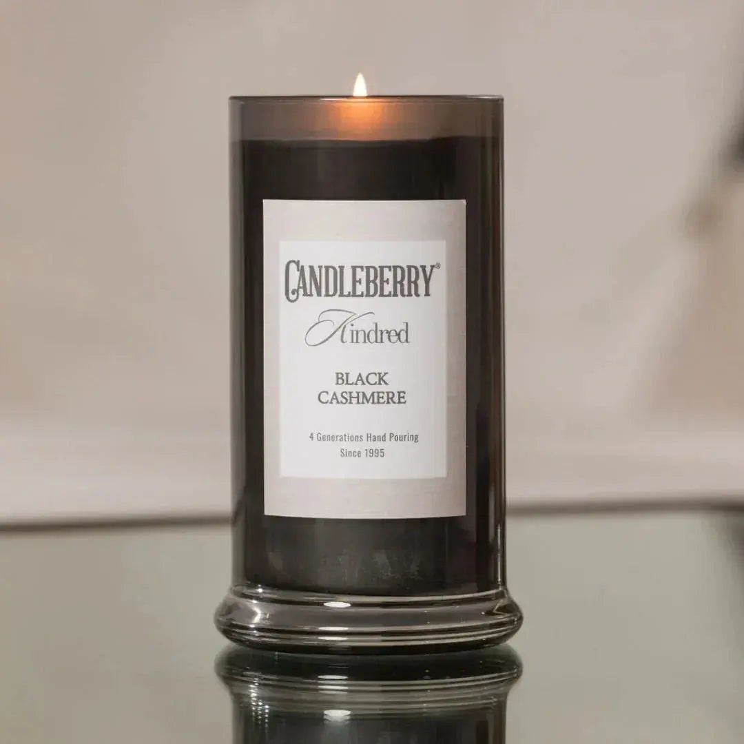 Candleberry Kindred Black Cashmere scented candle in dark glass jar, lit for cozy ambiance