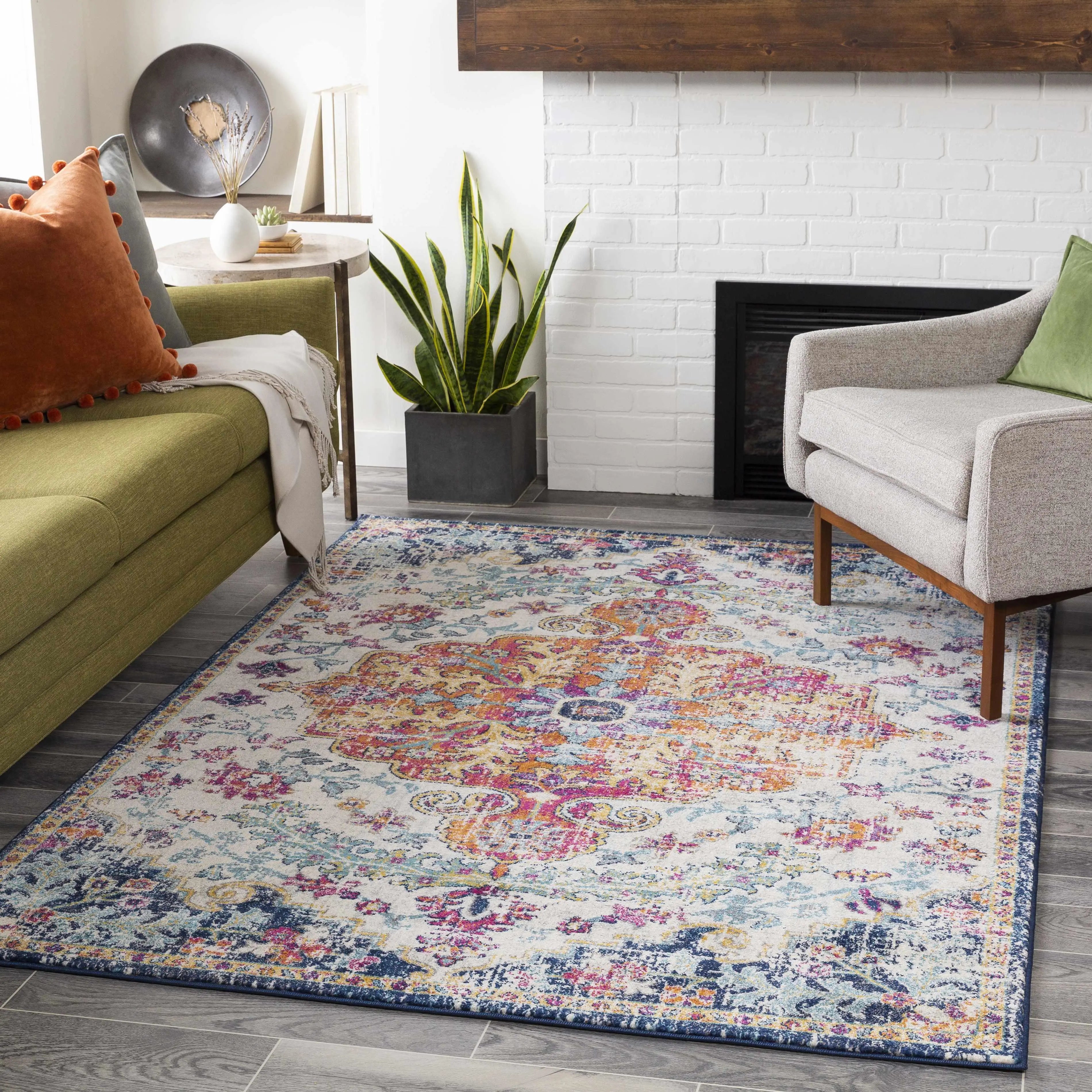 Colorful vintage-style area rug in cozy living room with green sofa and white brick fireplace