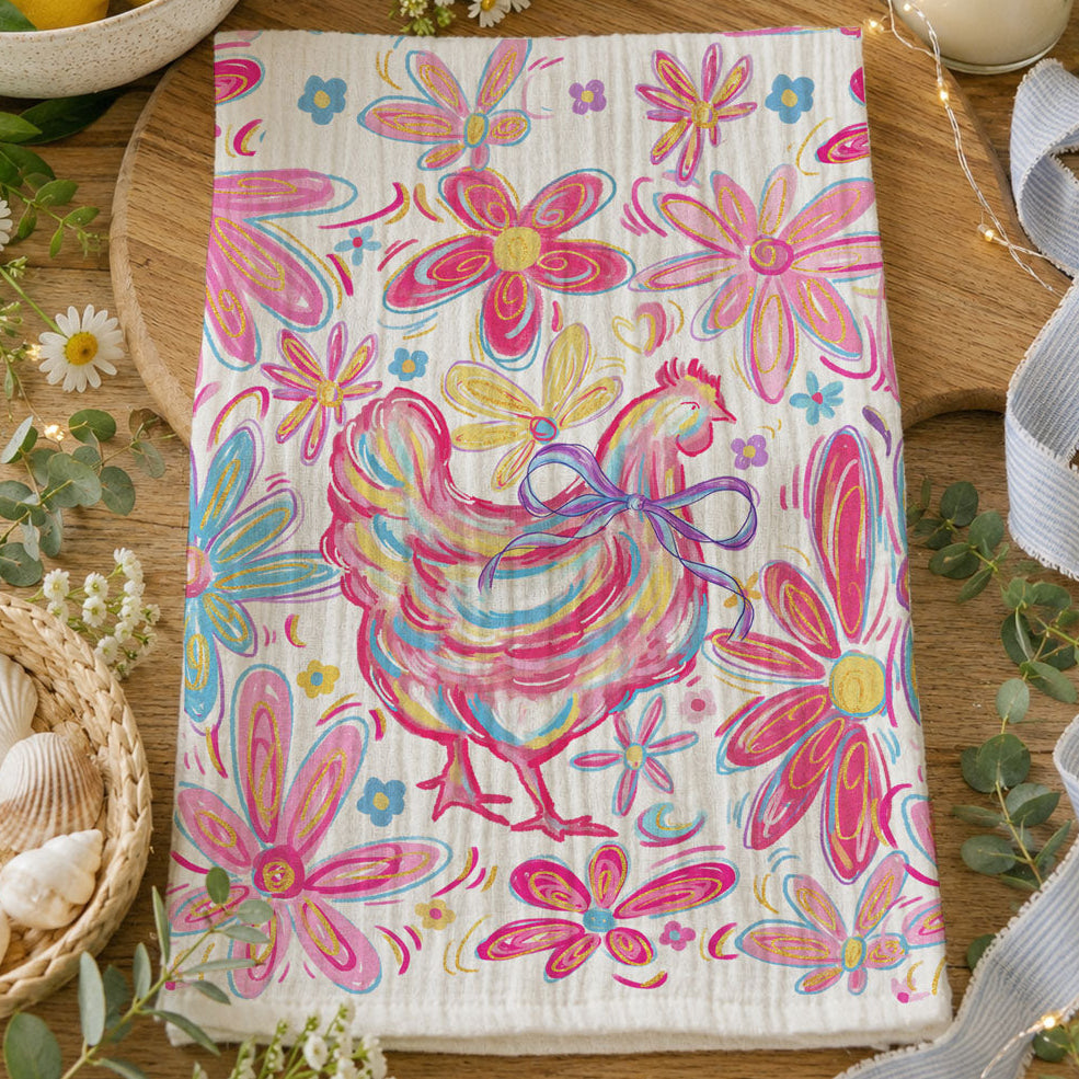 Colorful towel with rooster and floral design on a wooden surface