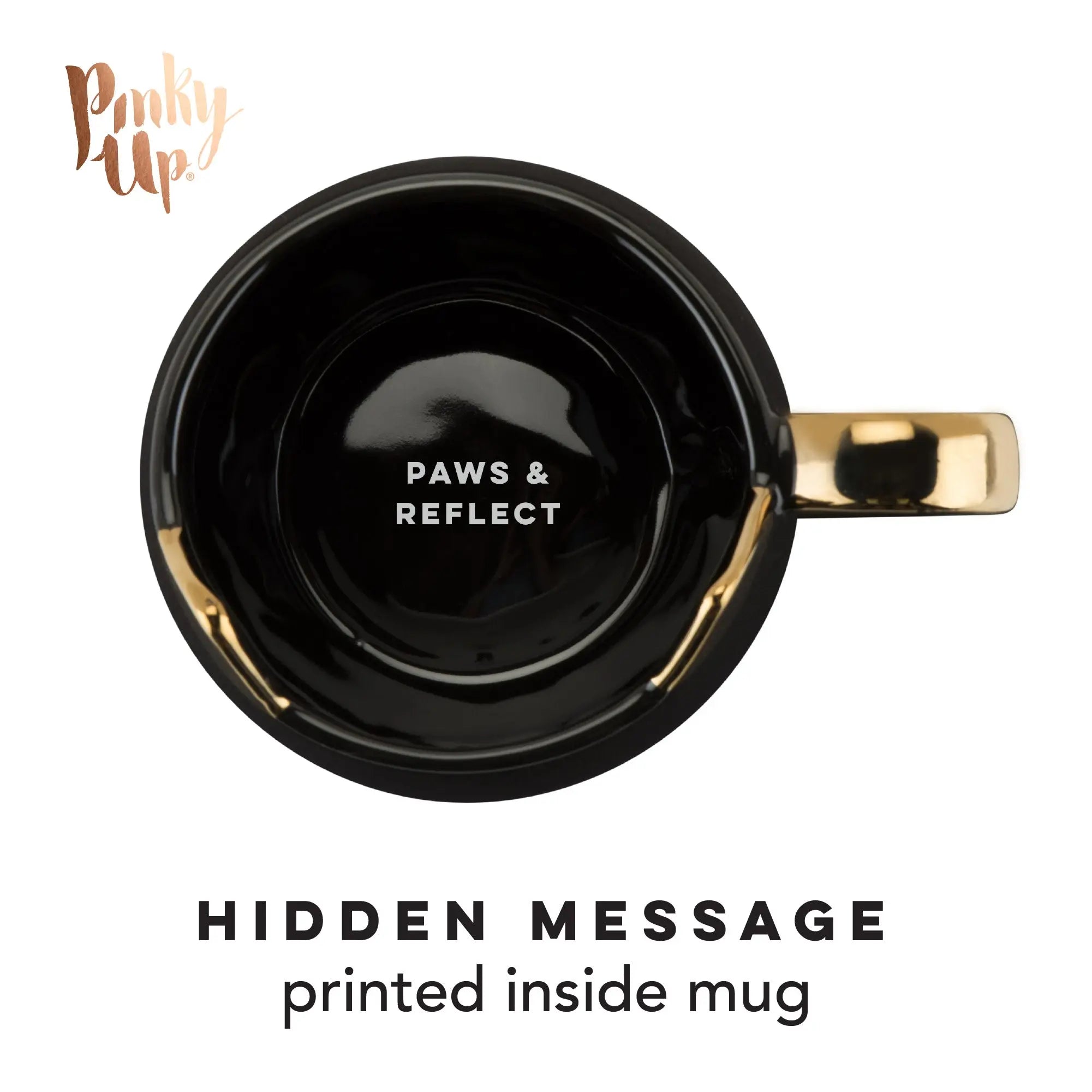 Black mug with gold handle featuring 'PAWS & REFLECT' text, branded 'Pinkly Up', on a white background.