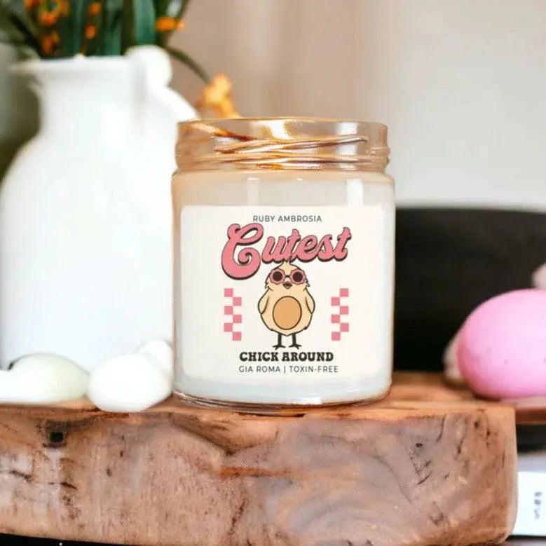 Candle with a cute label featuring a chick design on a wooden surface.