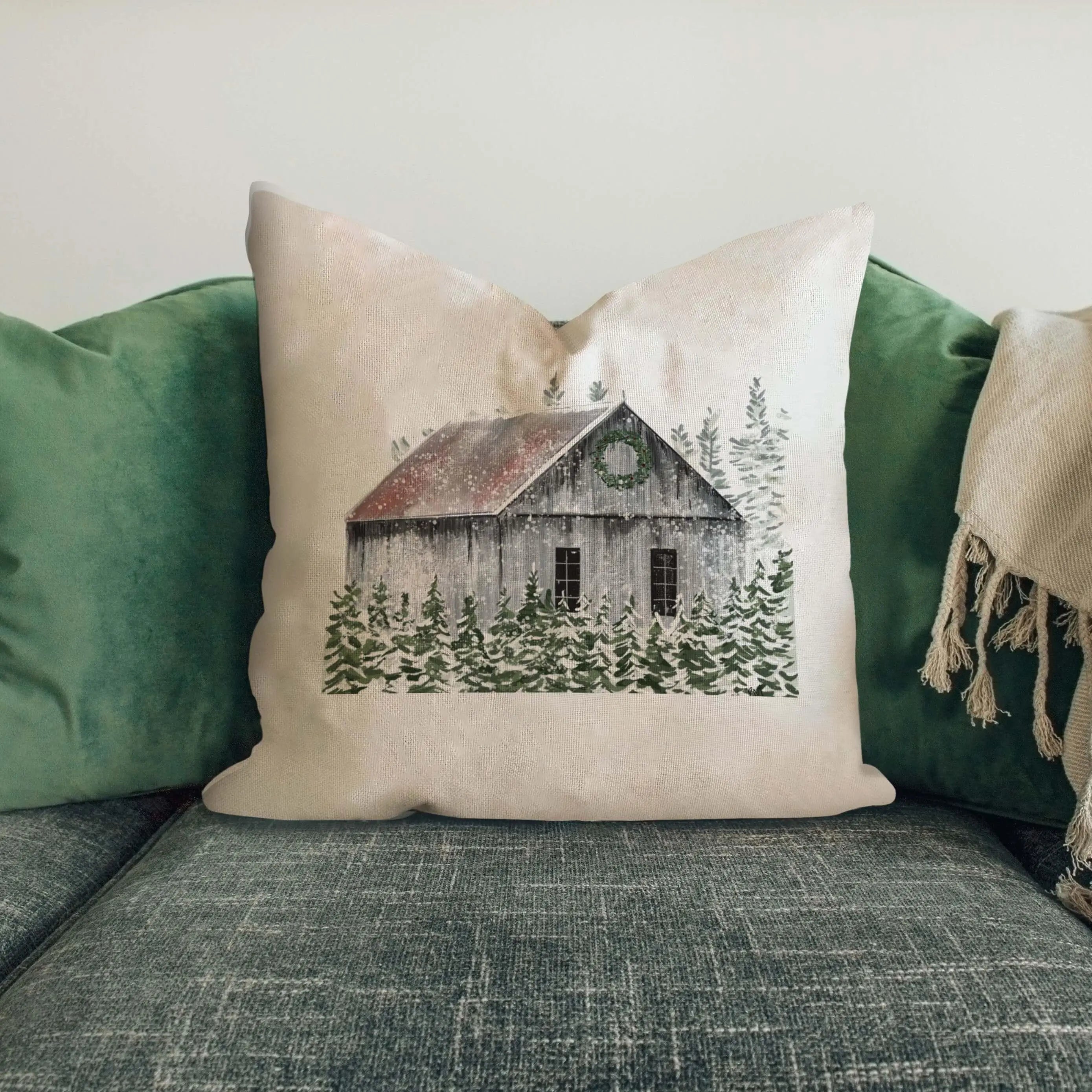 Cozy farmhouse pillow with snowy barn and evergreen trees, perfect for cottage-style home decor