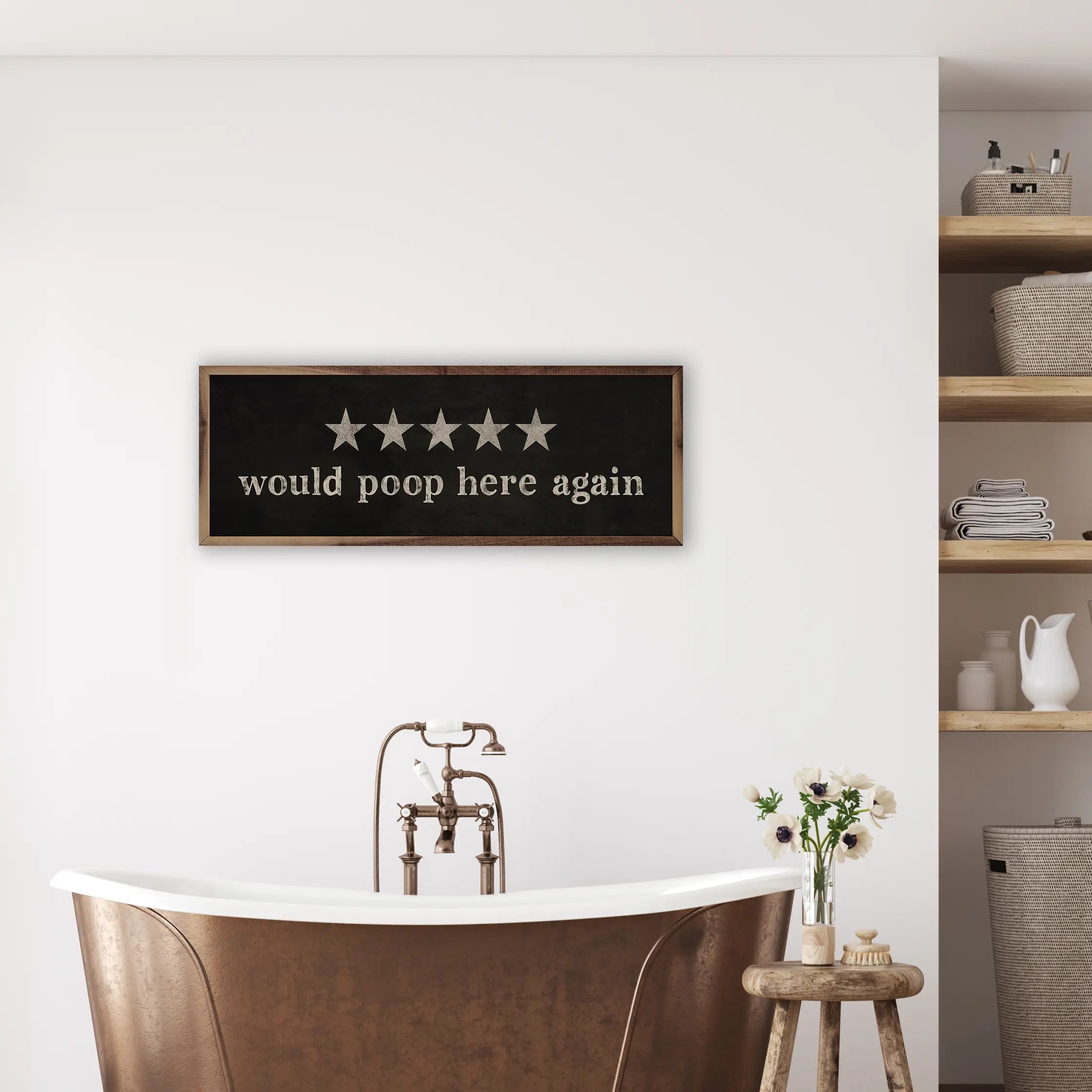 Bathroom interior with a framed sign above a bathtub, shelves with items in the background.