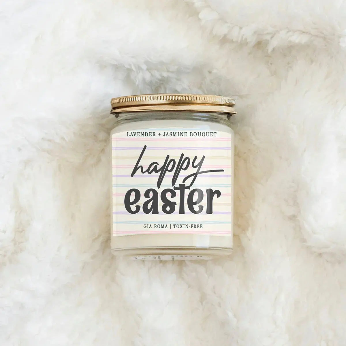Candle jar with 'Happy Easter' label on a fluffy white surface