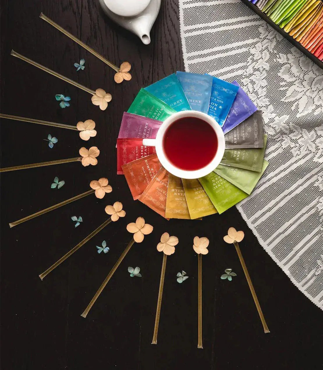 Cozy tea setup with colorful tea bags, dried flowers, and lace, perfect for farmhouse or cottage home decor