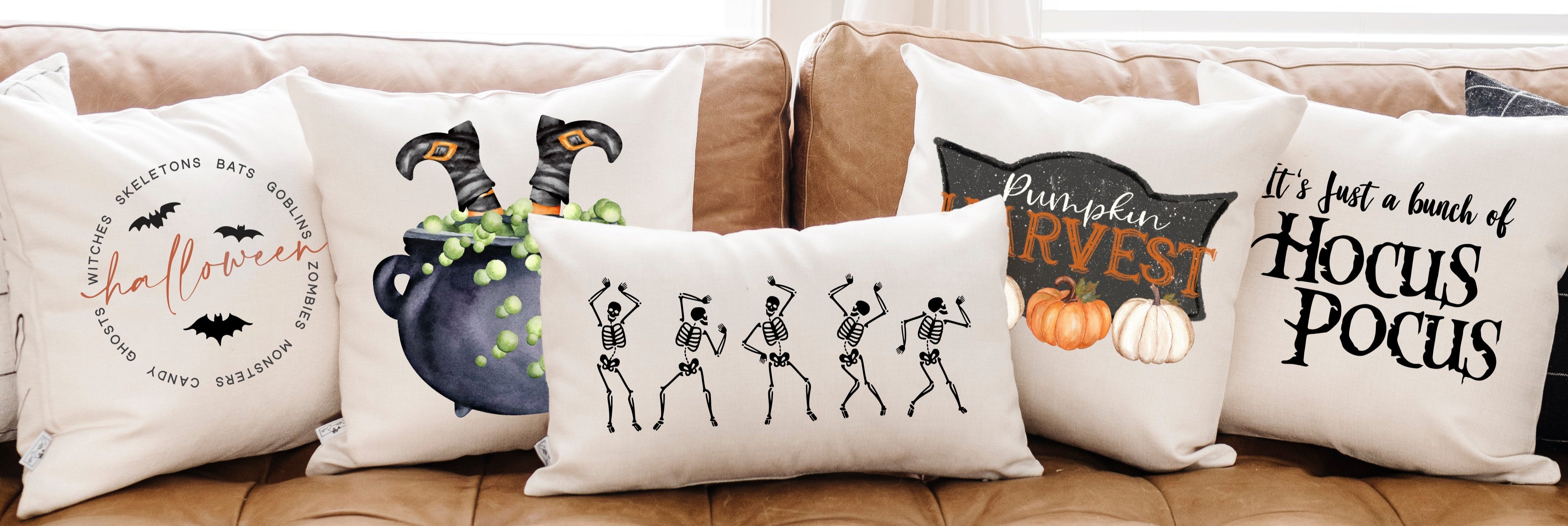 Set of Halloween-themed decorative pillows on a couch.