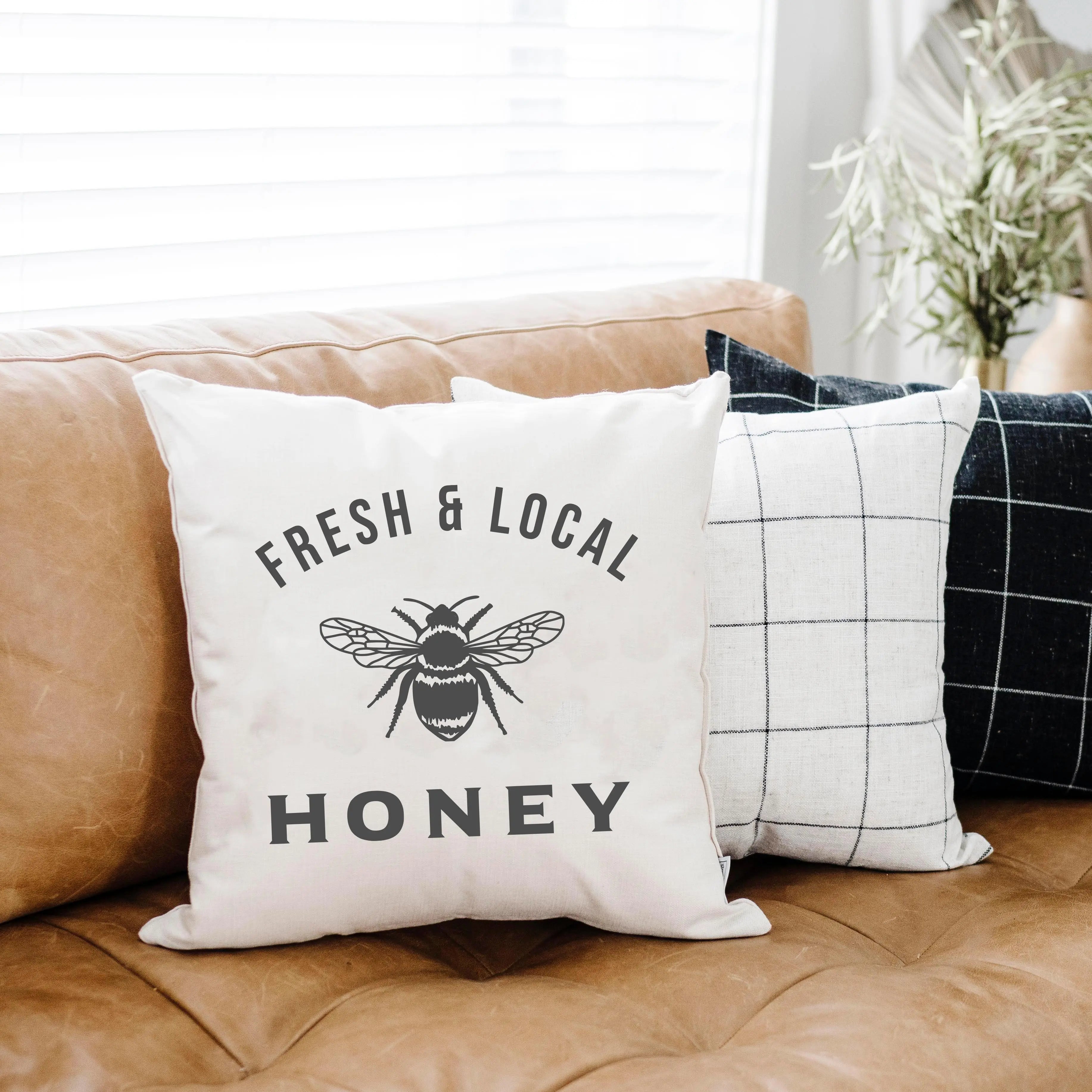 Fresh & Local Honey pillow with bee design on cozy farmhouse sofa, perfect for cottage style decor
