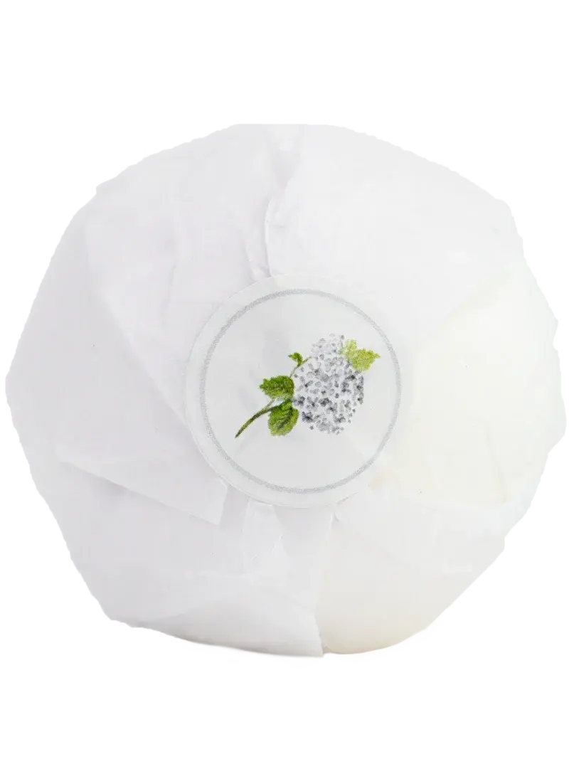 White bath bomb wrapped in tissue with hydrangea label, cozy farmhouse bath essential