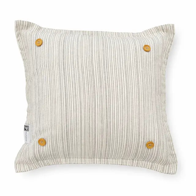 A square throw pillow with a vertical stripe pattern in beige and off-white, featuring four mustard yellow buttons on the corners and a small white tag on the left side, set against a plain white background.