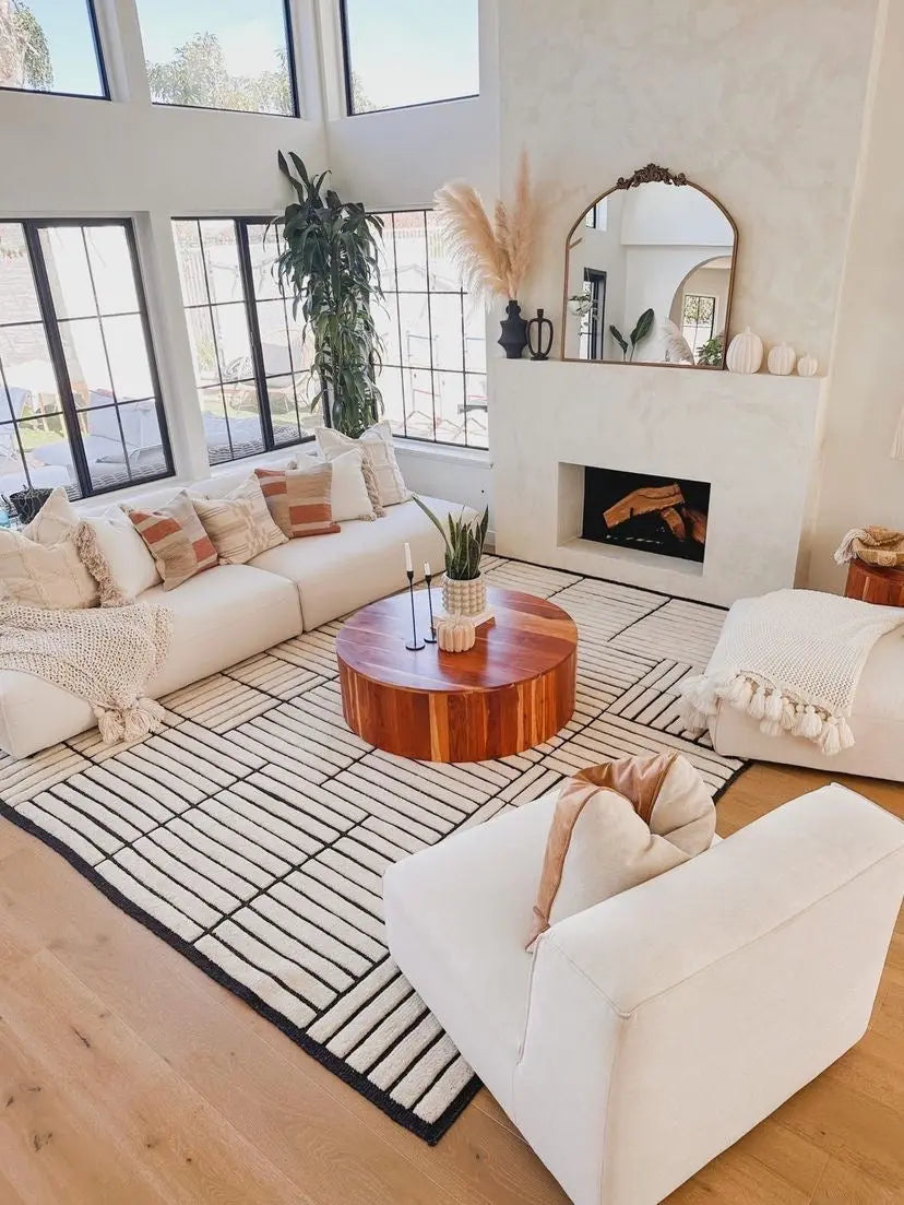 Modern living room with white sofas, a wooden coffee table, and a fireplace.