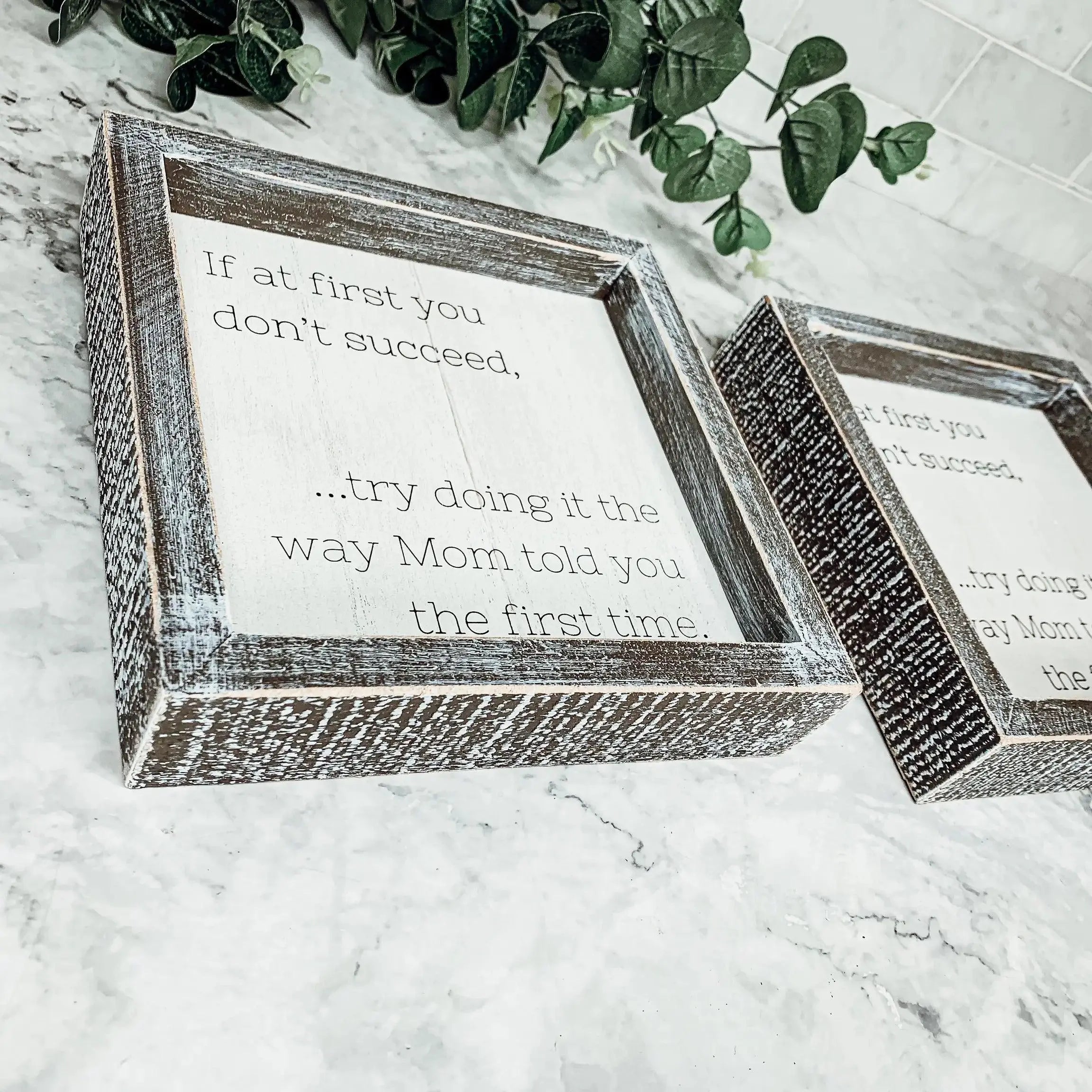 Wooden picture frames with motivational quote on a marble surface