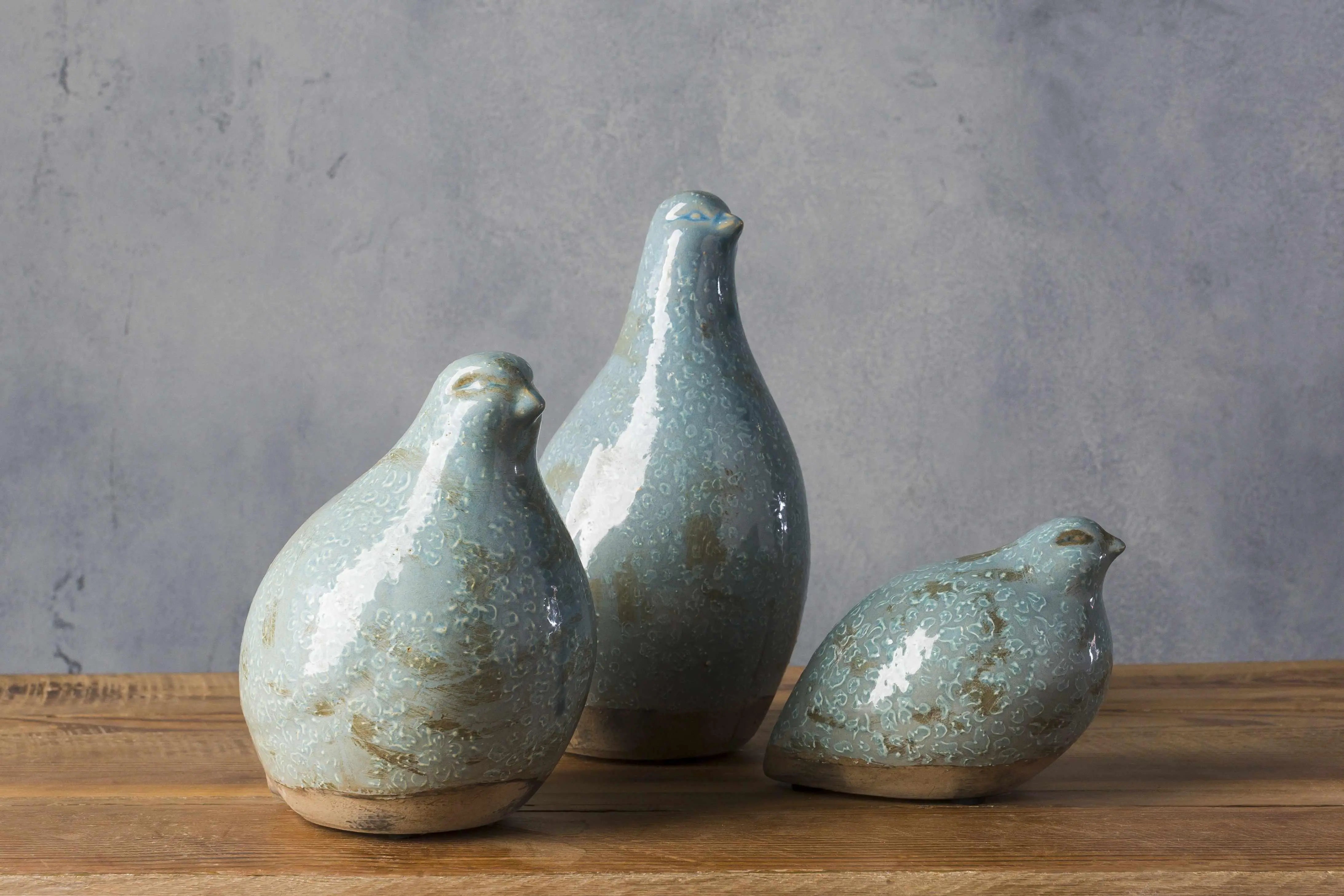 Set of three blue ceramic bird figurines for farmhouse decor on wooden shelf