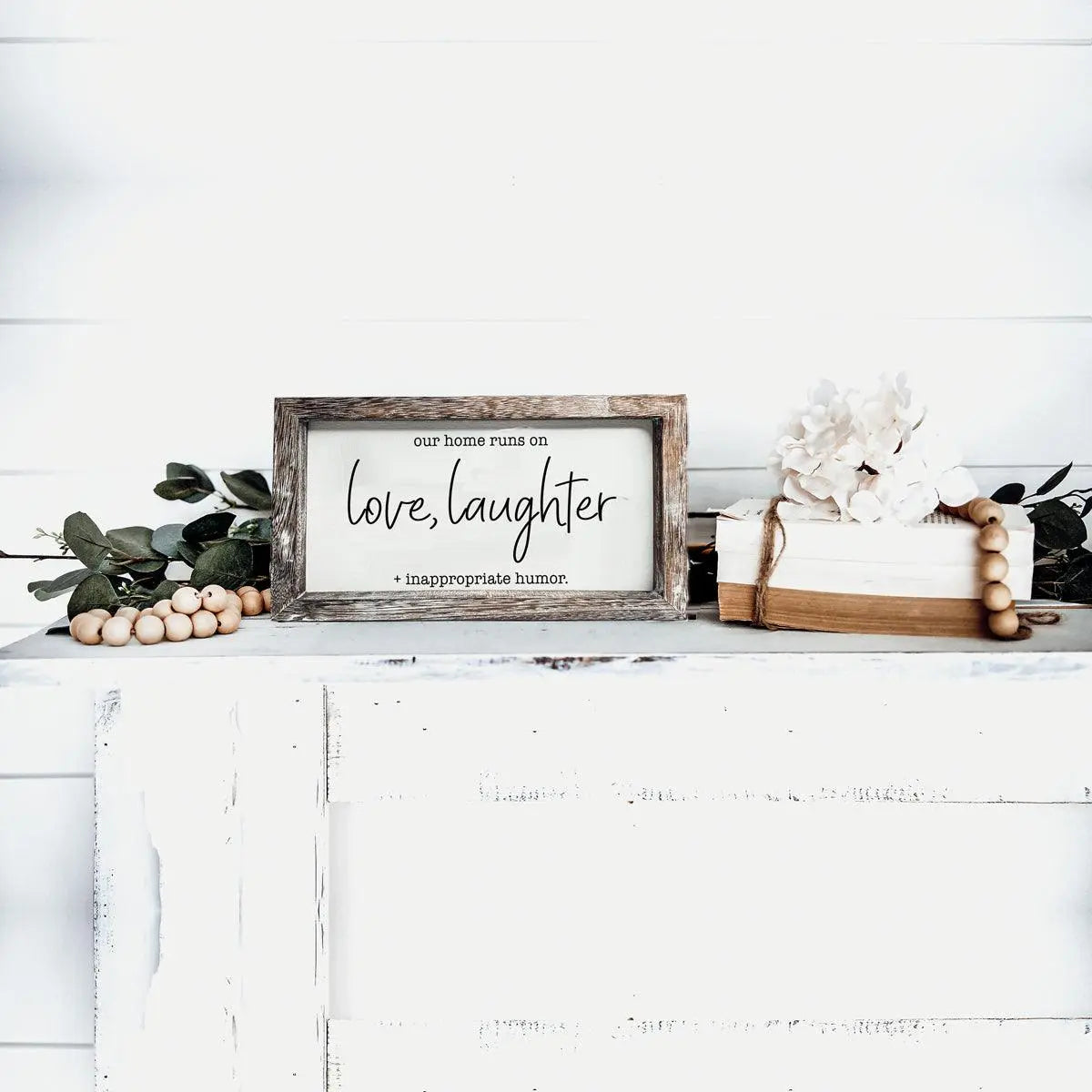 Framed sign with text on a white surface with decorative elements