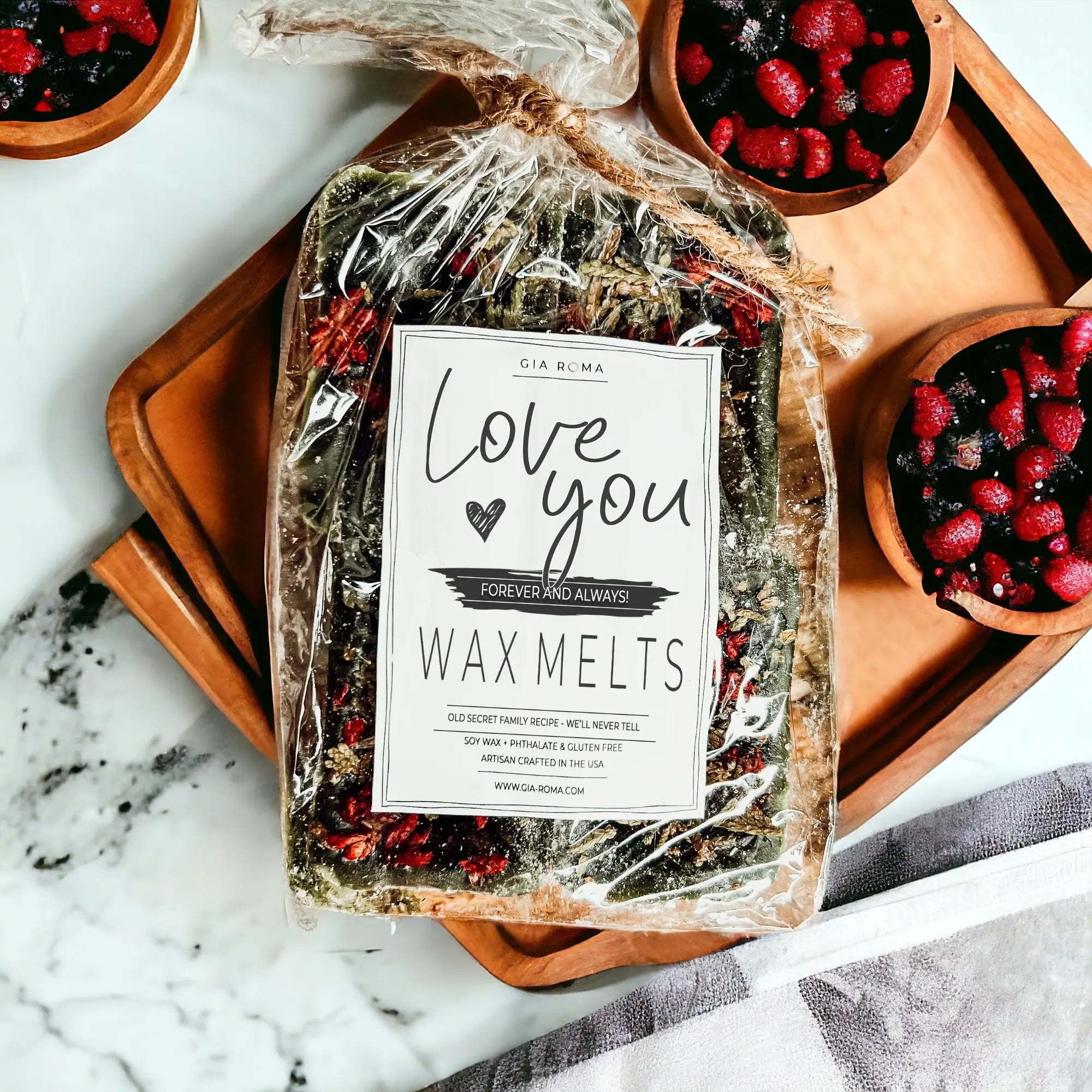 Packaged wax melts with a label on a marble surface with bowls of berries.