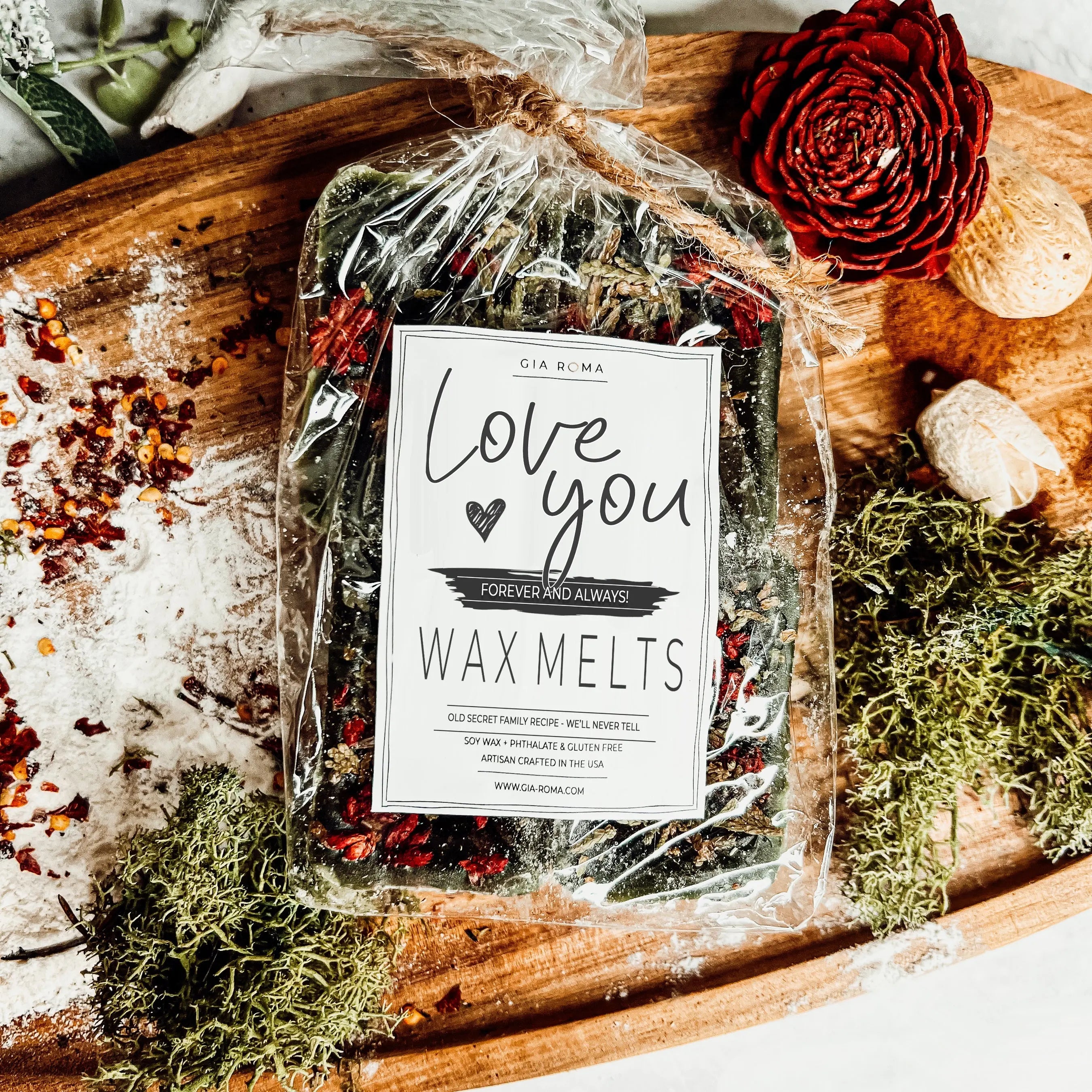 Packaged wax melts with a 'Love you' label on a decorative wooden surface.