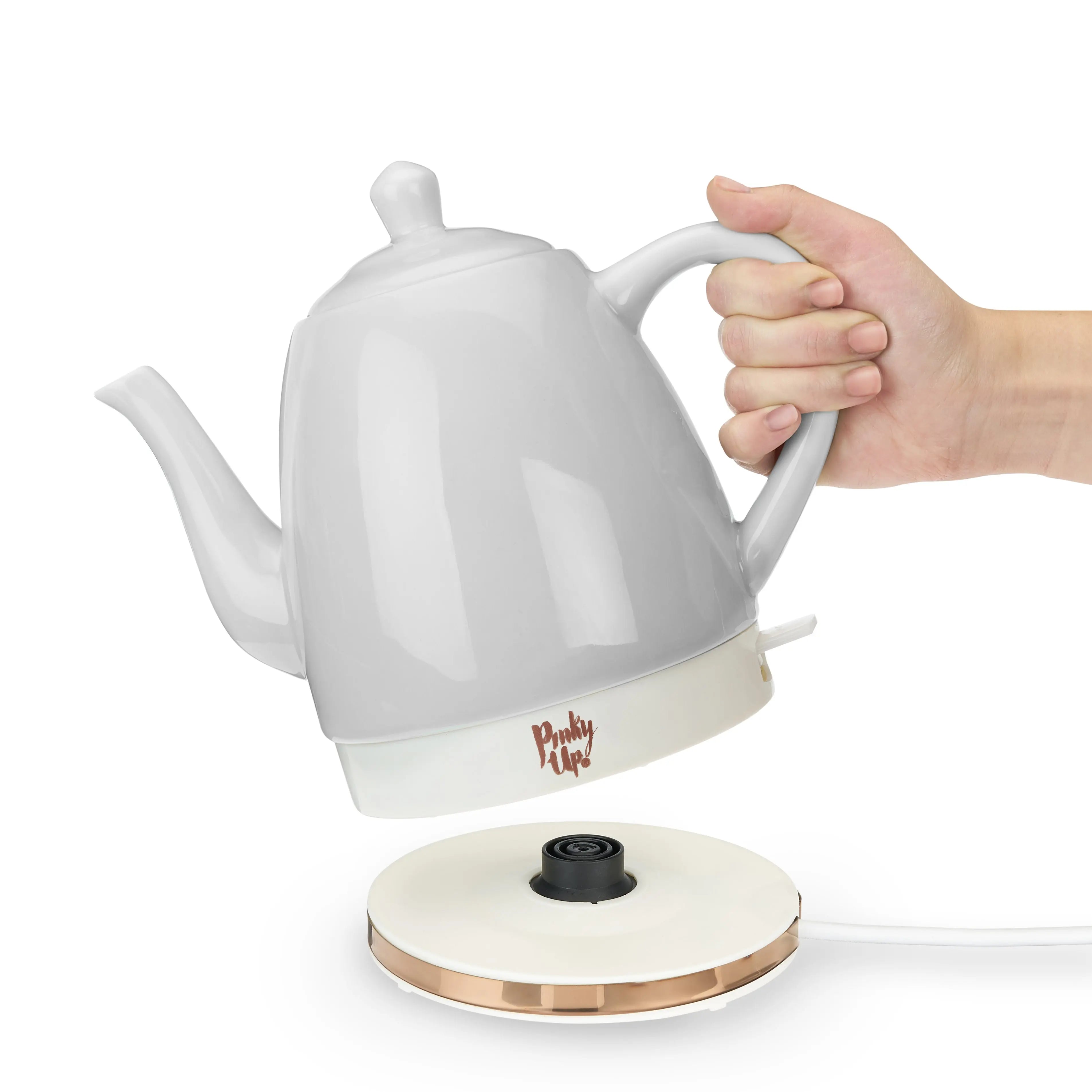 White electric kettle with a hand holding it on a white background